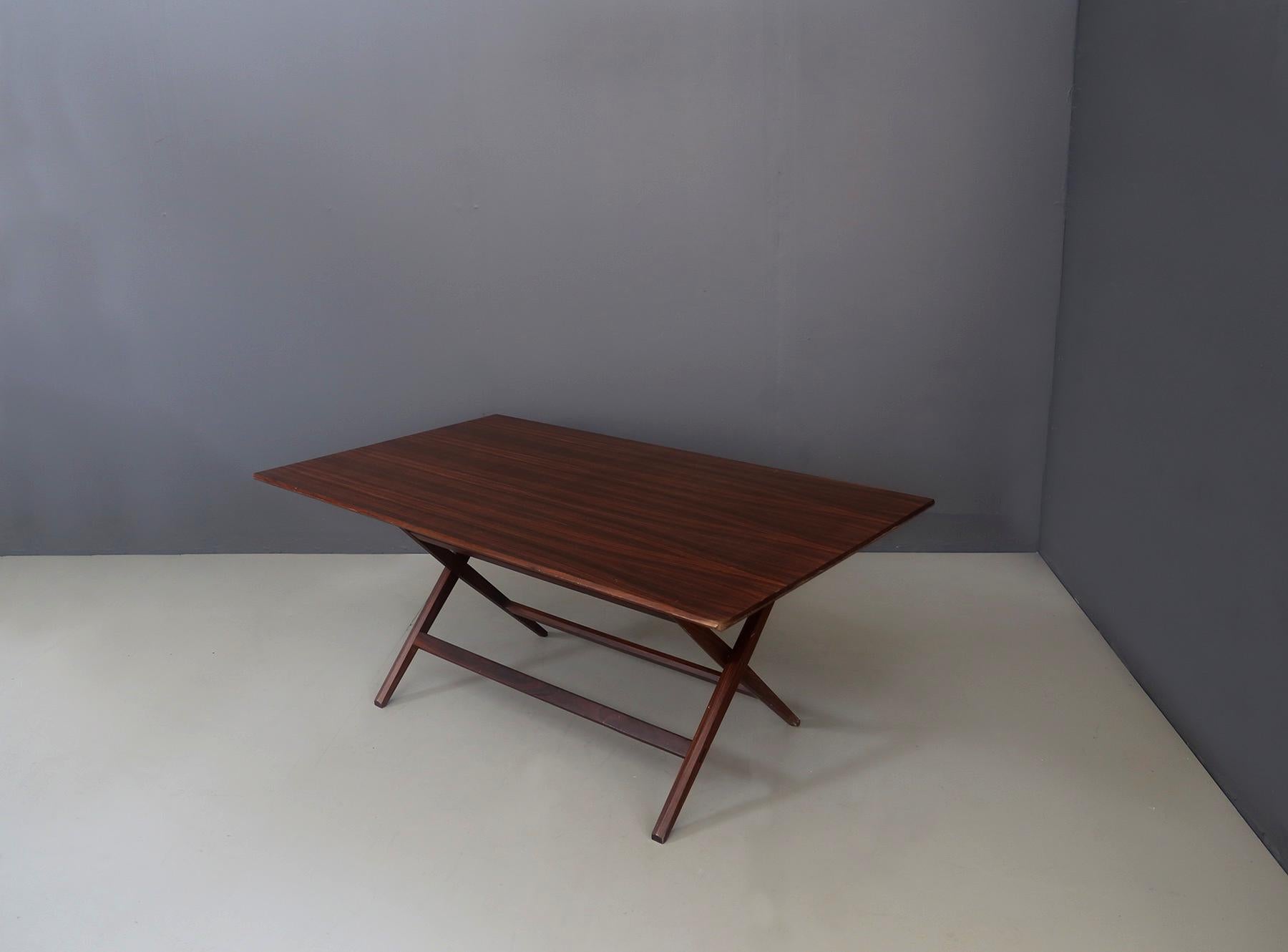 Rare trestle table by Franco Albini from 1950. The table is made entirely of walnut wood. Its legs, made in an X-shape, close easily towards the inside to allow its complete closure and its wooden support surface is completely detached from the legs
