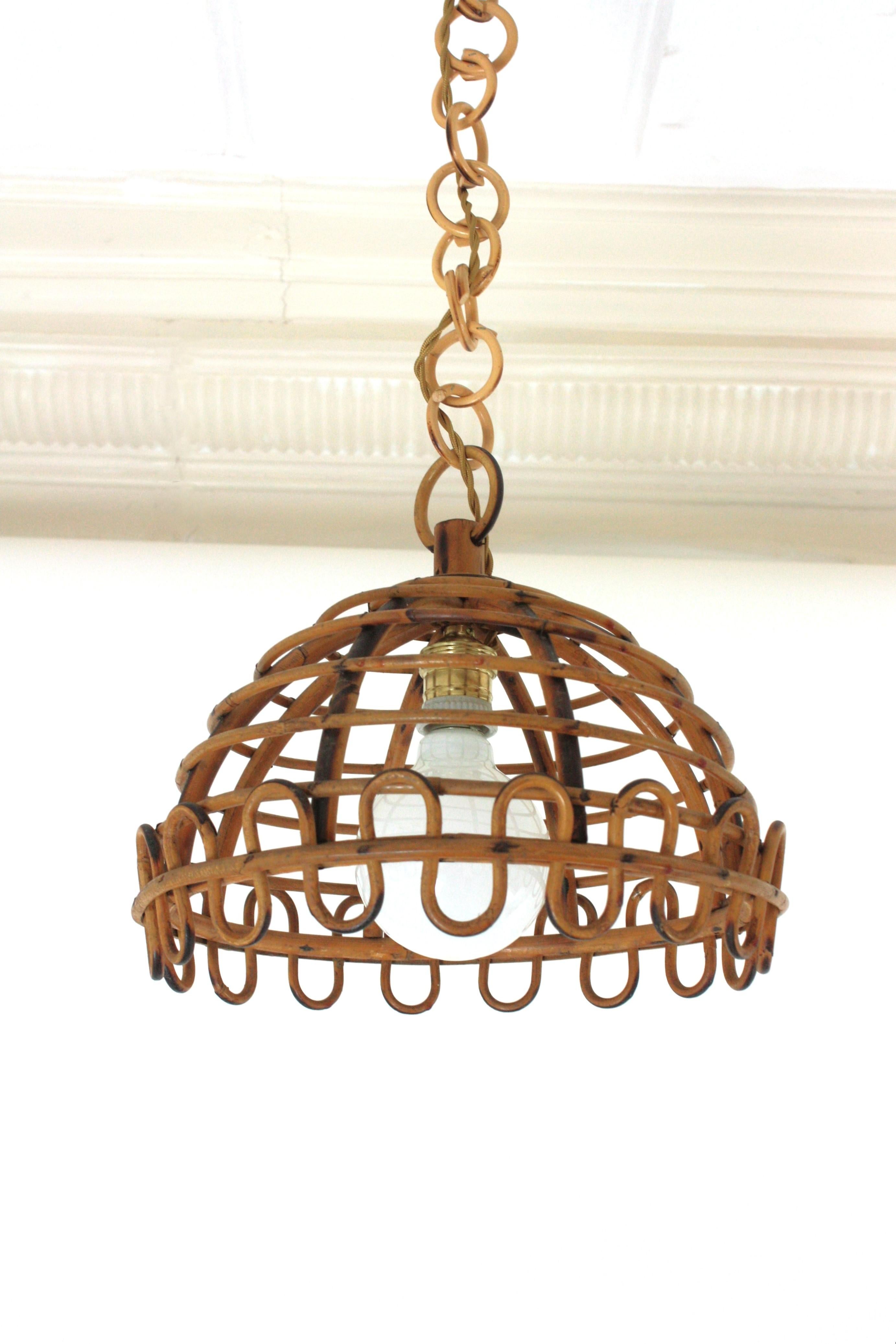 Eye-catching rattan pendant lamp with reminiscenses of the Franco Albini rattan mirrors design.
The Dome shaped lampshade has horizontal rattan canes and undulate ending bottom. The lampshed hangs from a chain made of rattan links. On the top it has