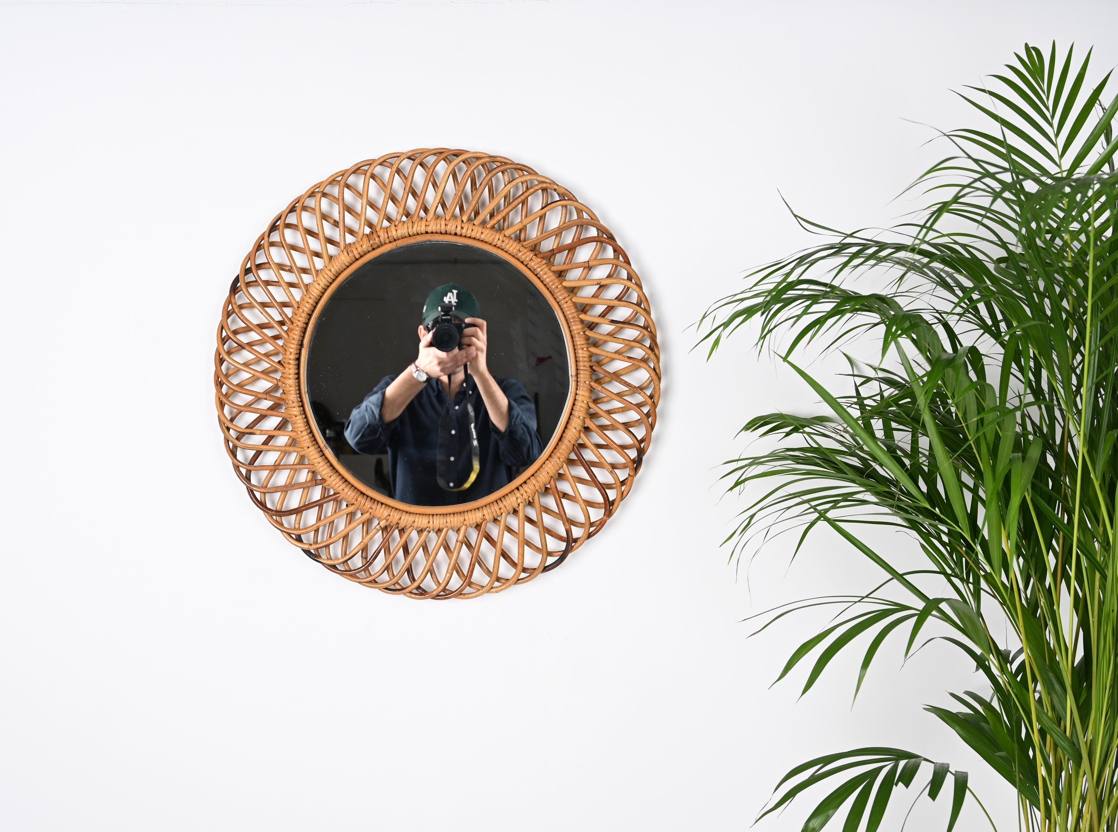 Amazing midcentury French Riviera rattan and bamboo round mirror. This marvellous object is attributed to Franco Albini as designer and Bonacina and was produced in Italy during the 1960s.

This decorative oval mirror is unique as it has a curved