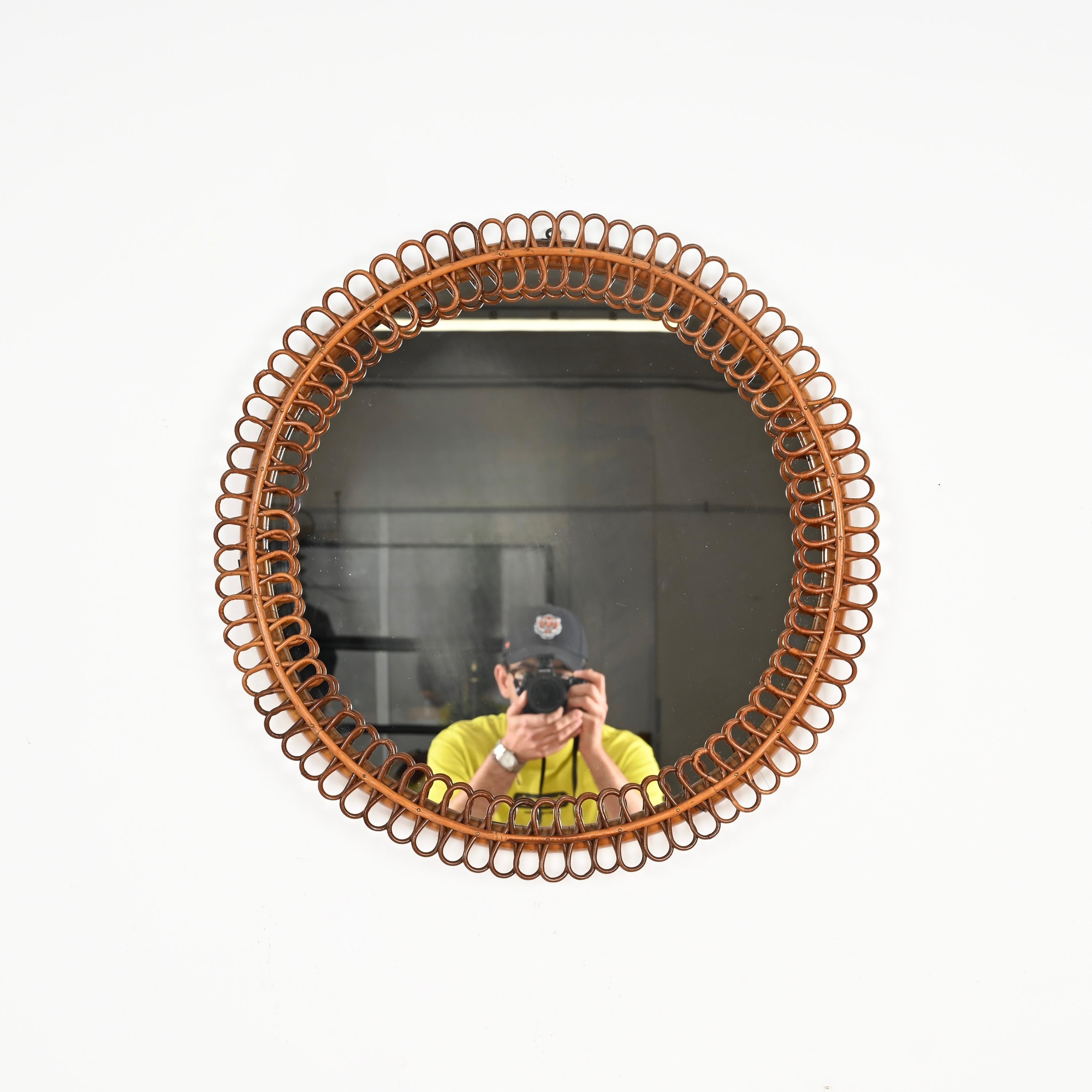 Remarquable miroir rond de style Côte d'Azur, entièrement réalisé en rotin et bambou courbé. Ce miroir spectaculaire et unique a été conçu par la maîtrise de Franco Albini et produit en Italie dans les années 1960. 

En parfait état et d'une