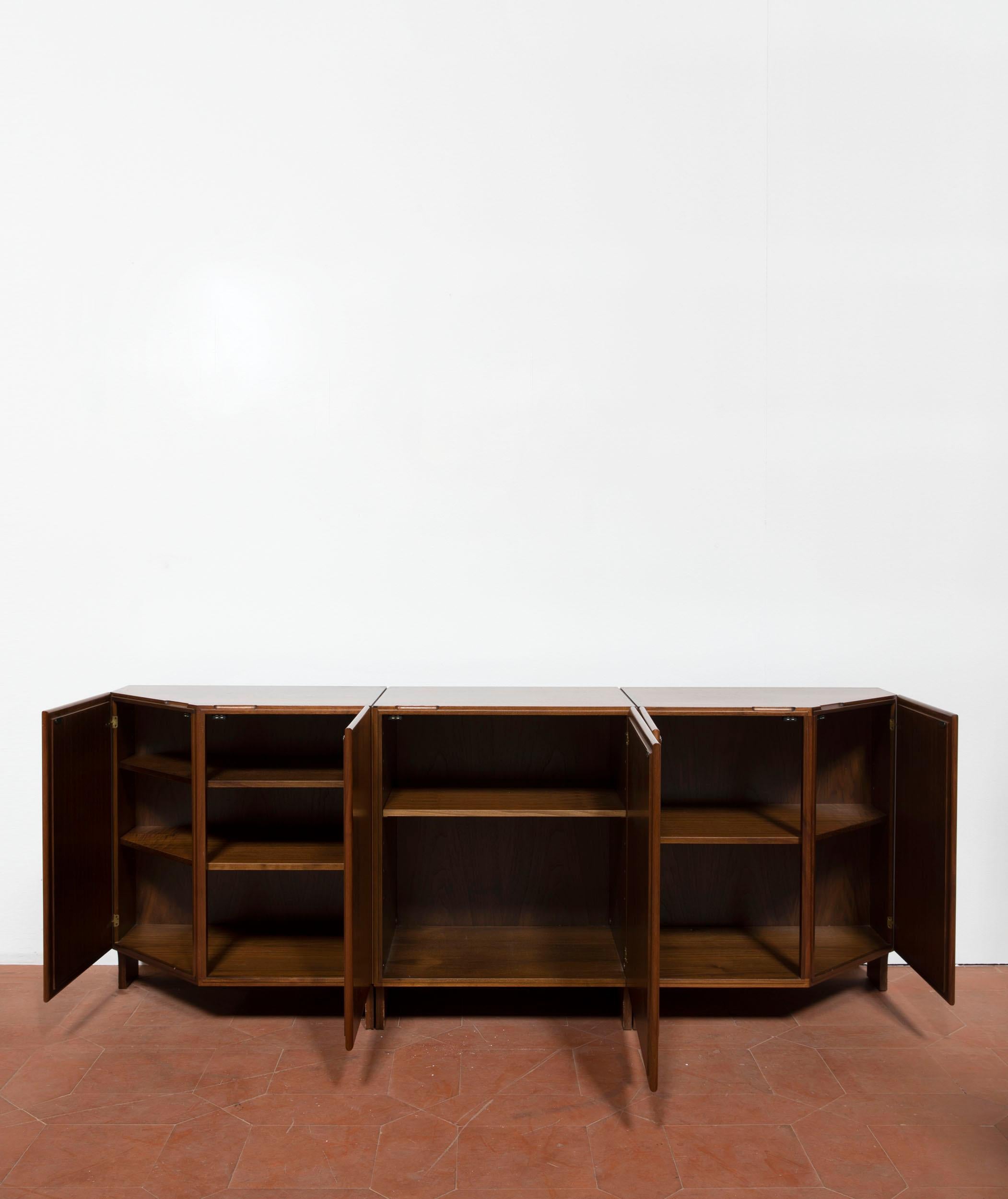 Franco Albini sideboard in walnuts wood. The elegant sideboard has five shutters and various shelves. This piece has a peculiar and geometrical shape.