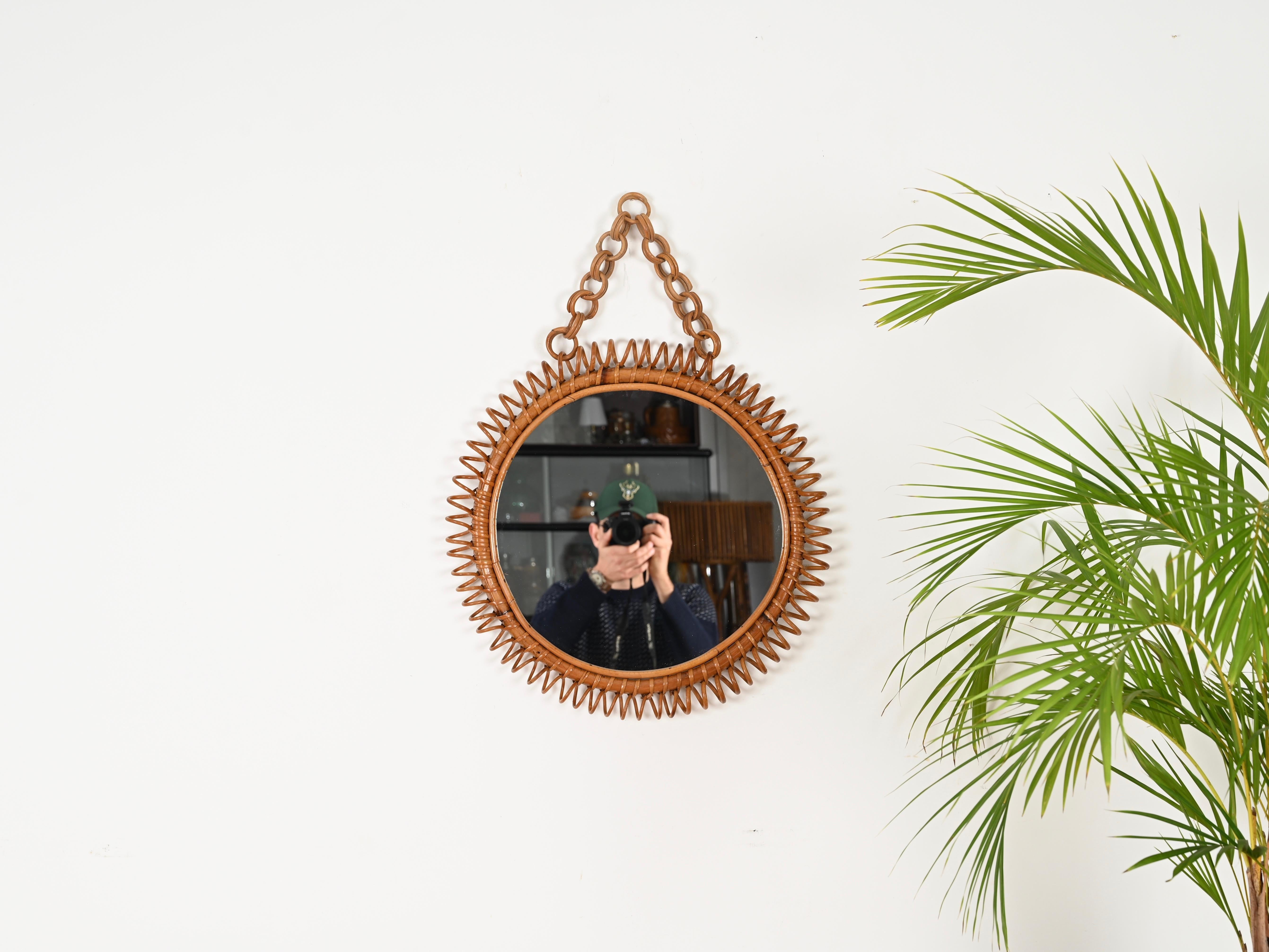 Splendido specchio rotondo del Mid-Century con catena completamente realizzato in rattan curvato, bambù e vimini intrecciato a mano. Questo specchio in stile Costa Azzurra, incredibilmente affascinante, è attribuito alla maestria di Franco Albini ed