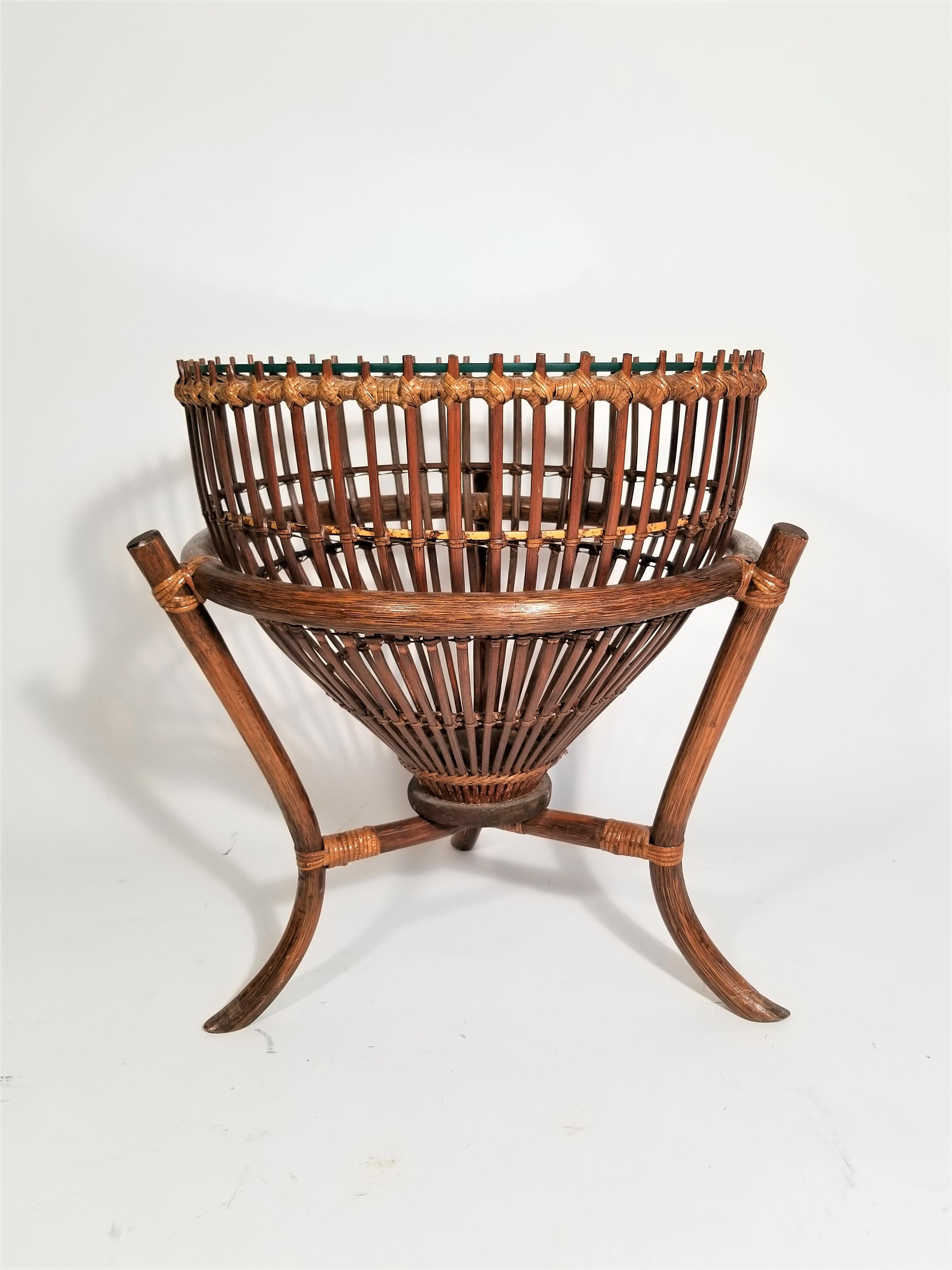 Stunning and unique midcentury Franco Albini style rattan fishing basket table. Side table or end table. We also have 2 available in a larger size. 
Glass top is new and in excellent condition.
Quarter inch plated glass.
Glass top diameter 18.25