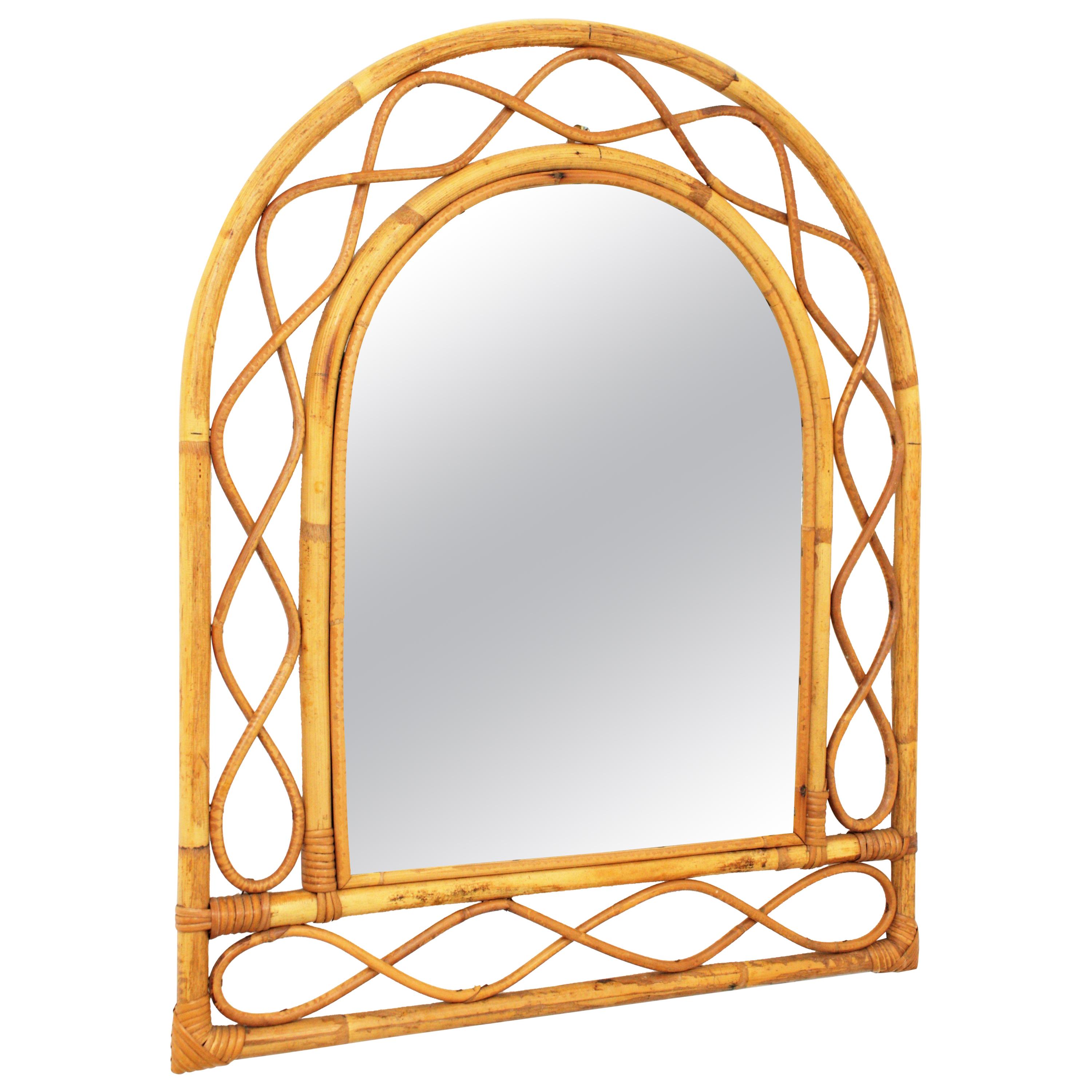 Lovely Mid-Century Modern Franco Albini style handcrafted bamboo and rattan mirror with arched top.
This mirror features a double bamboo frame with decorative rattan undulations between the bamboo canes.
This bamboo mirror will be a nice addition