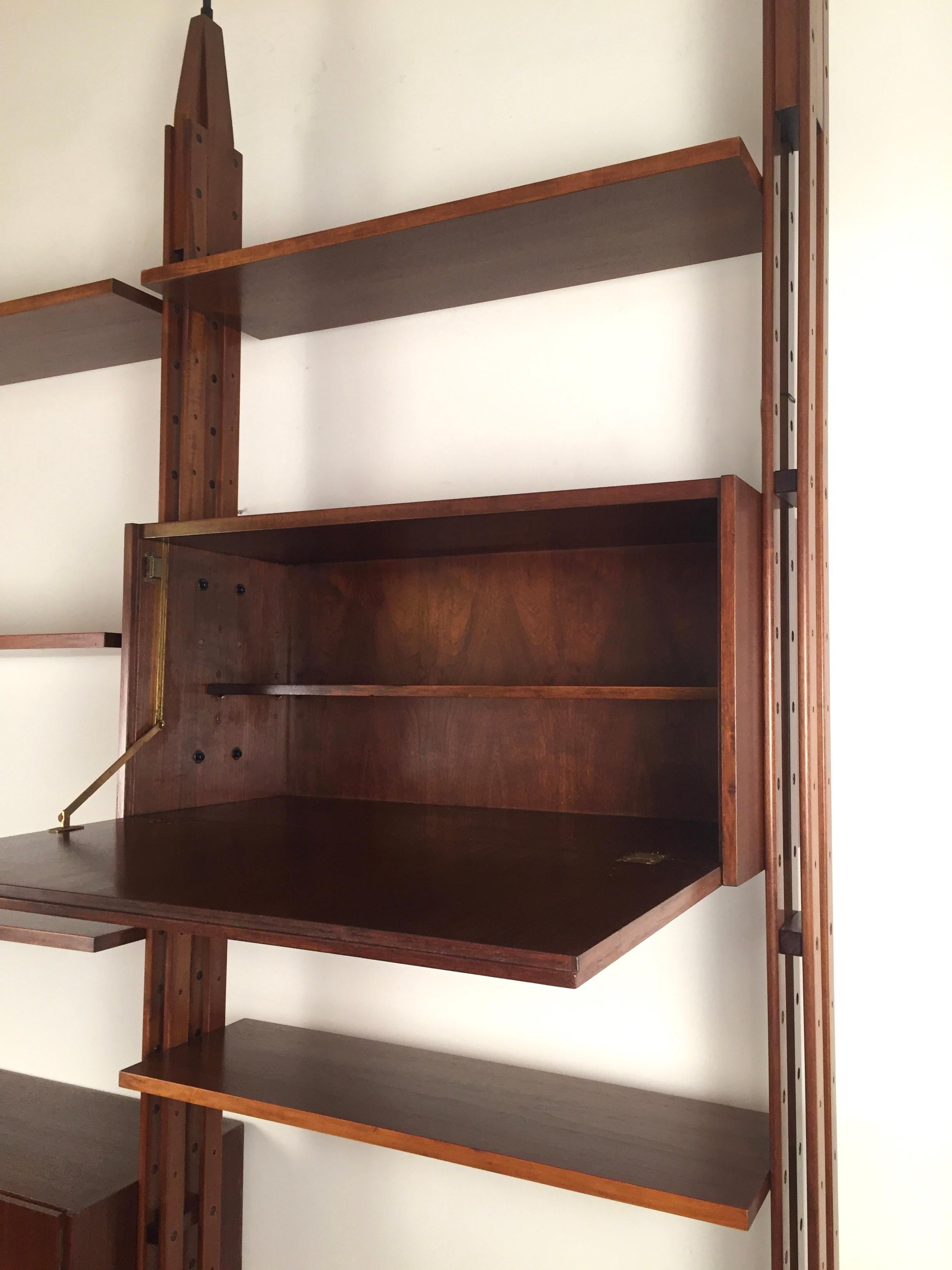 A two modular teak bookcase, Designed by Franco Albini and edited in 1956 by Poggi, Pavia, Marked. Composed of two modules with storages units and shelves. Black laquered metal ends,
Measures: Minimum height:267 cm. Maximum height : 273