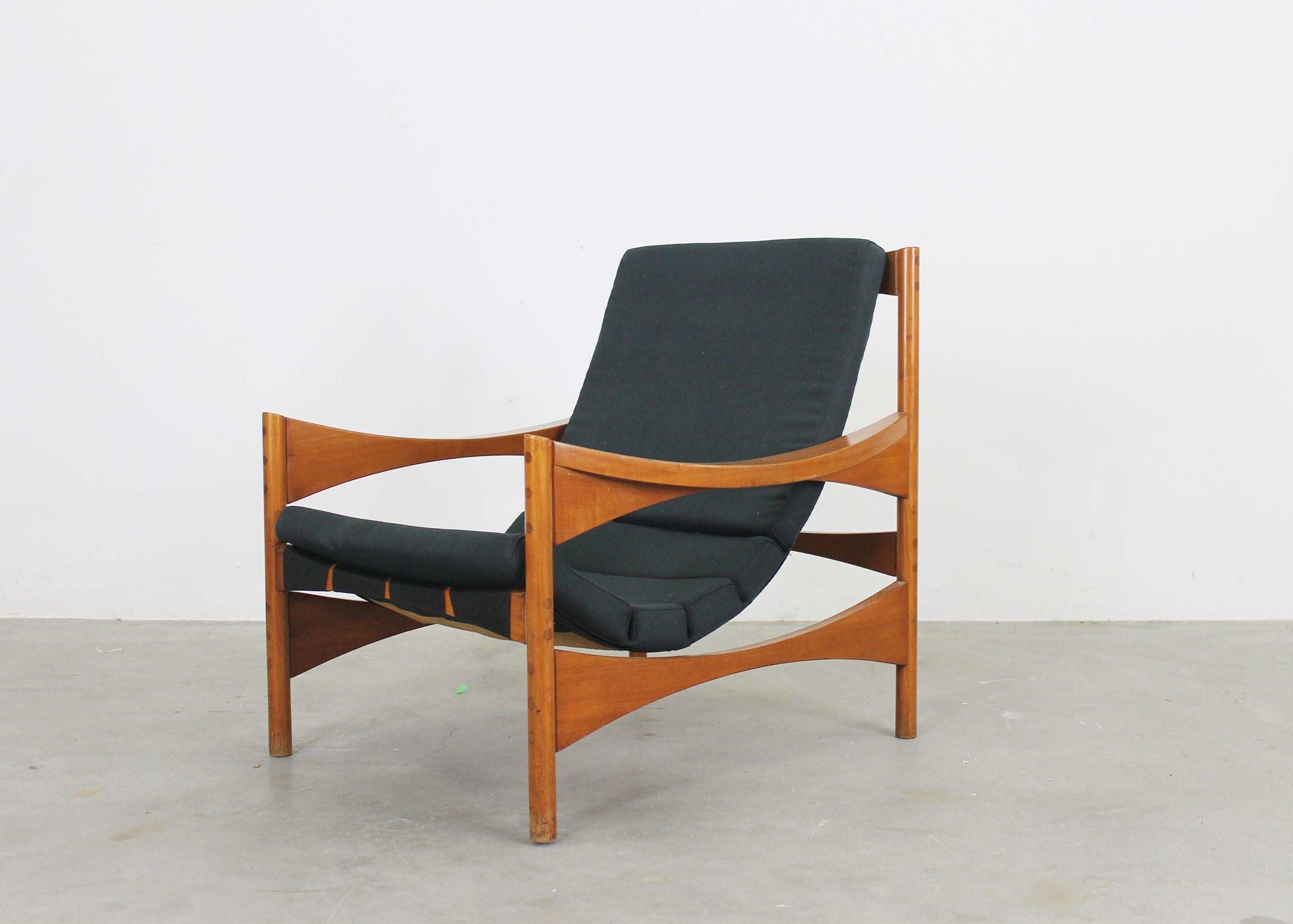 P 40 armchair with structure in walnut wood, the seat and back are composed of a removable padded cushion covered with fabric and sustained by a fabric structure directly attached to the wooden structure. 
It was designed by Franco Bettonica in 1959