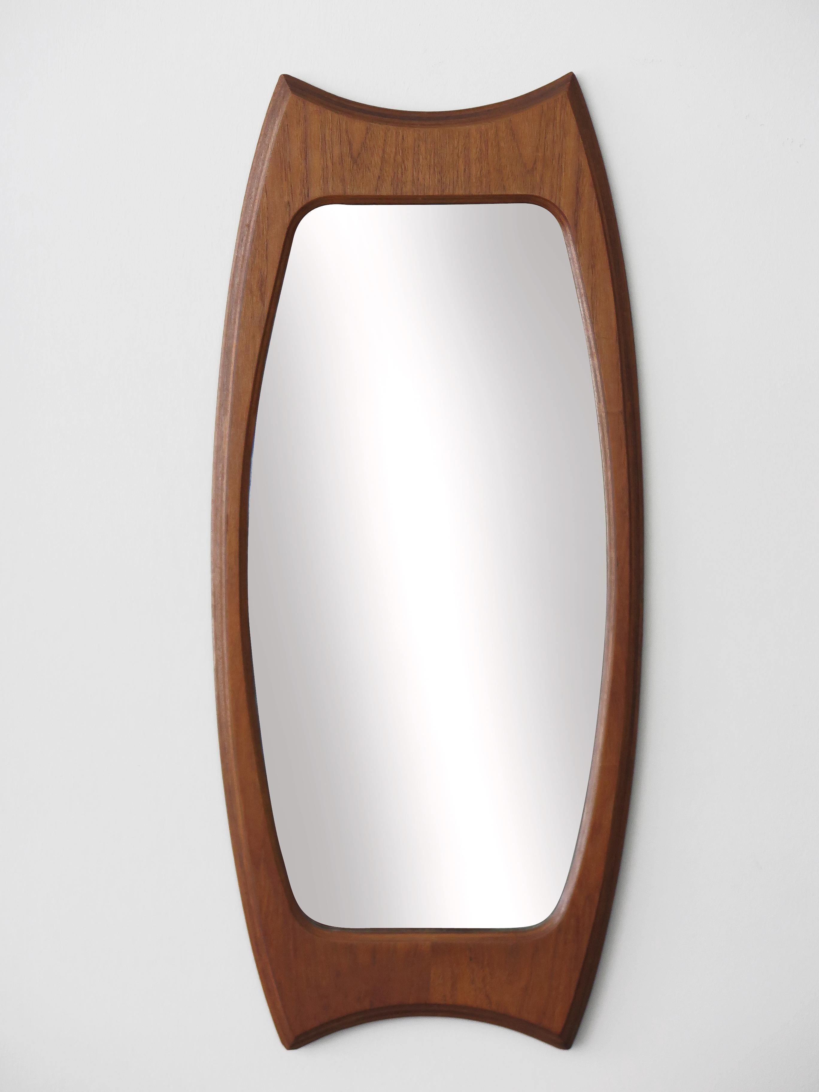 Italian midcentury wall mirror designed by Franco Campo & Carlo Graffi and produced by Home with molded teak frame, stamped ‘Home design Campo and Graffi’ on the back, 1950s.

Please note that the mirror is original of the period and this shows