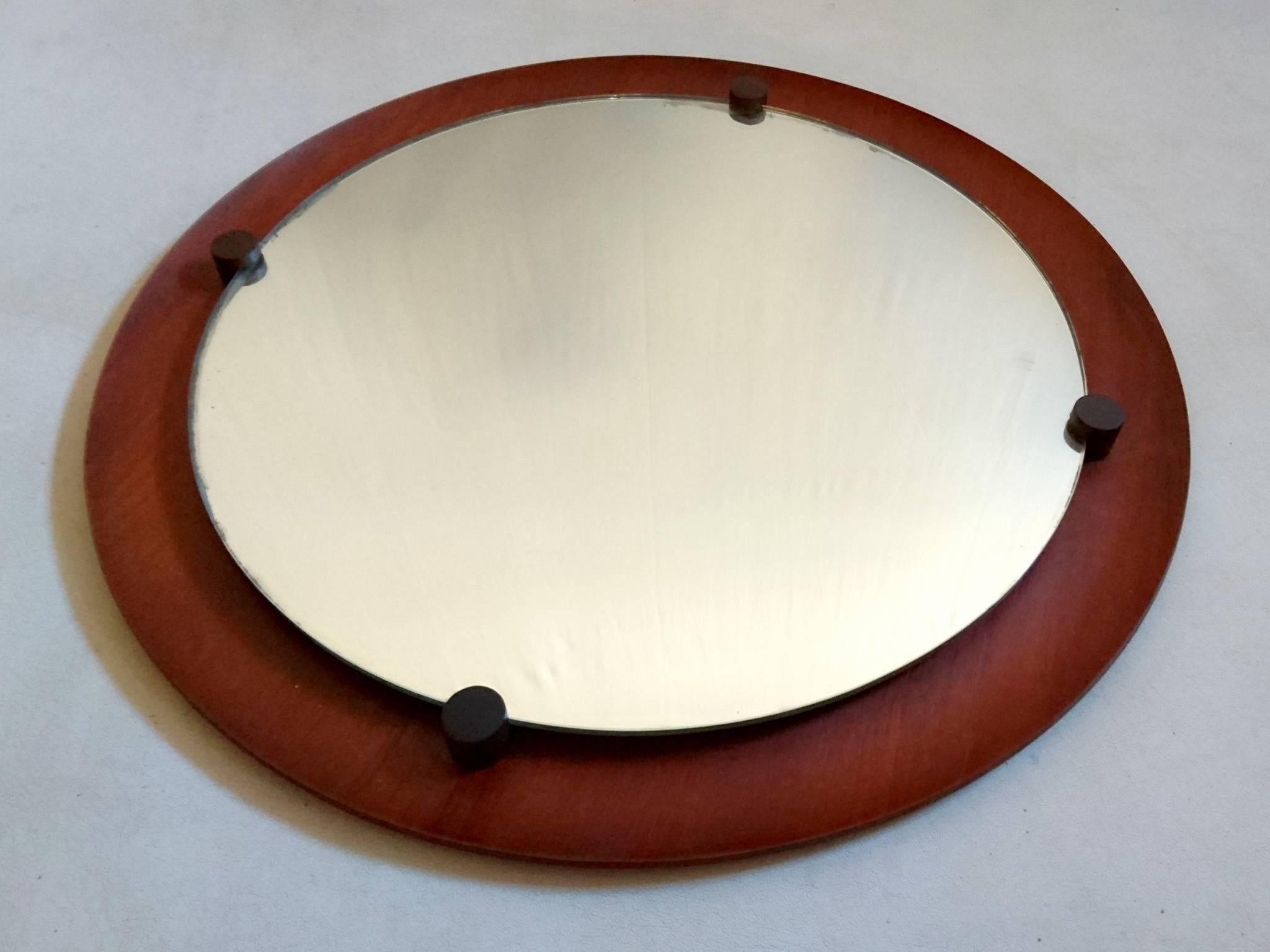 A large round teak frame raised mirror with rosewood pegs by Franco Campo & Carlo Graffi. Very nice condition.