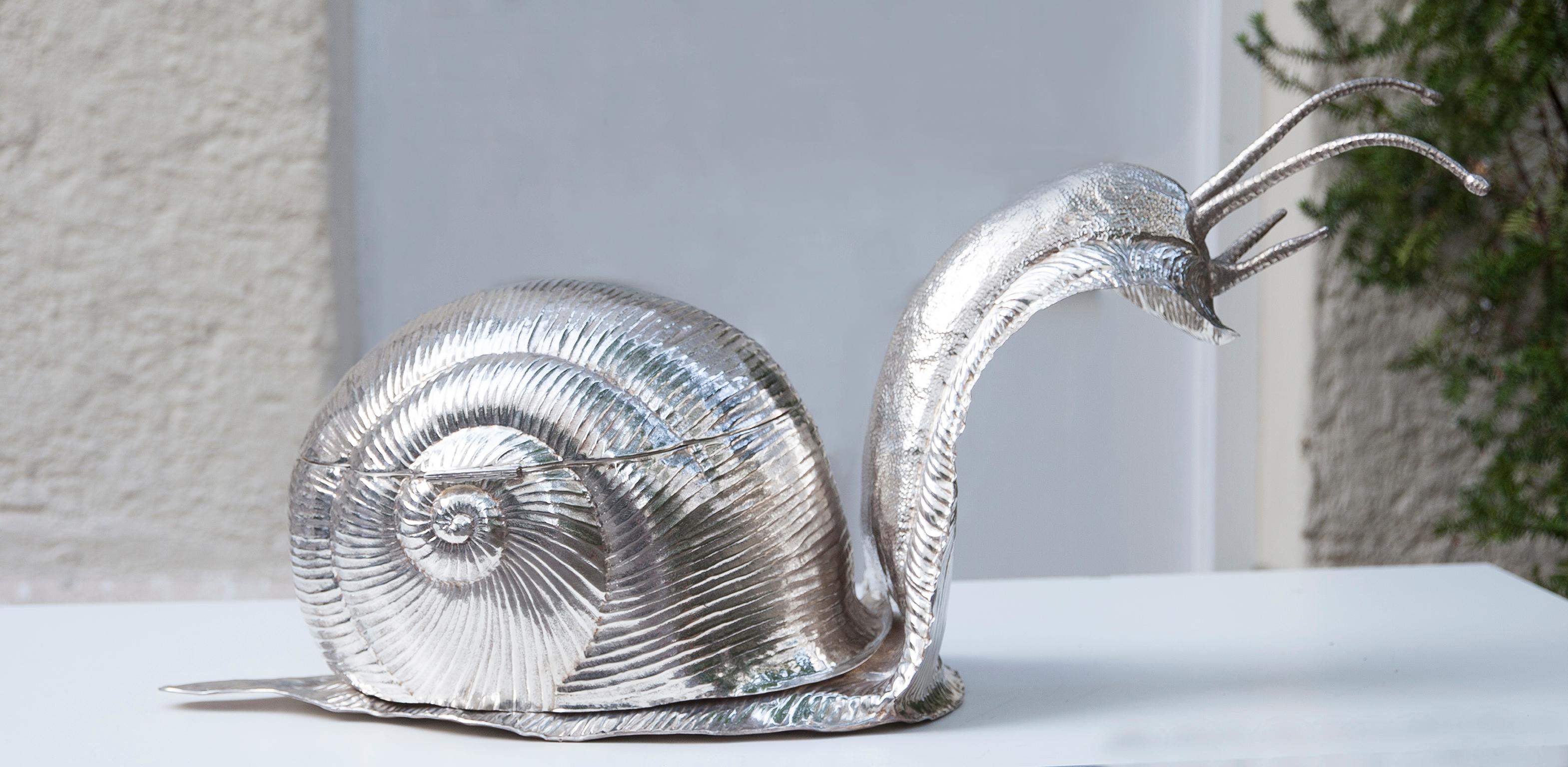 Franco Lapinis exquisite snail soup bowl is made entirely of metal plated in silver and its surface is lightly textured to give it an organic feel. When you open the back, there are two removable glass inlays plus a pepper and salt Shaker. Either