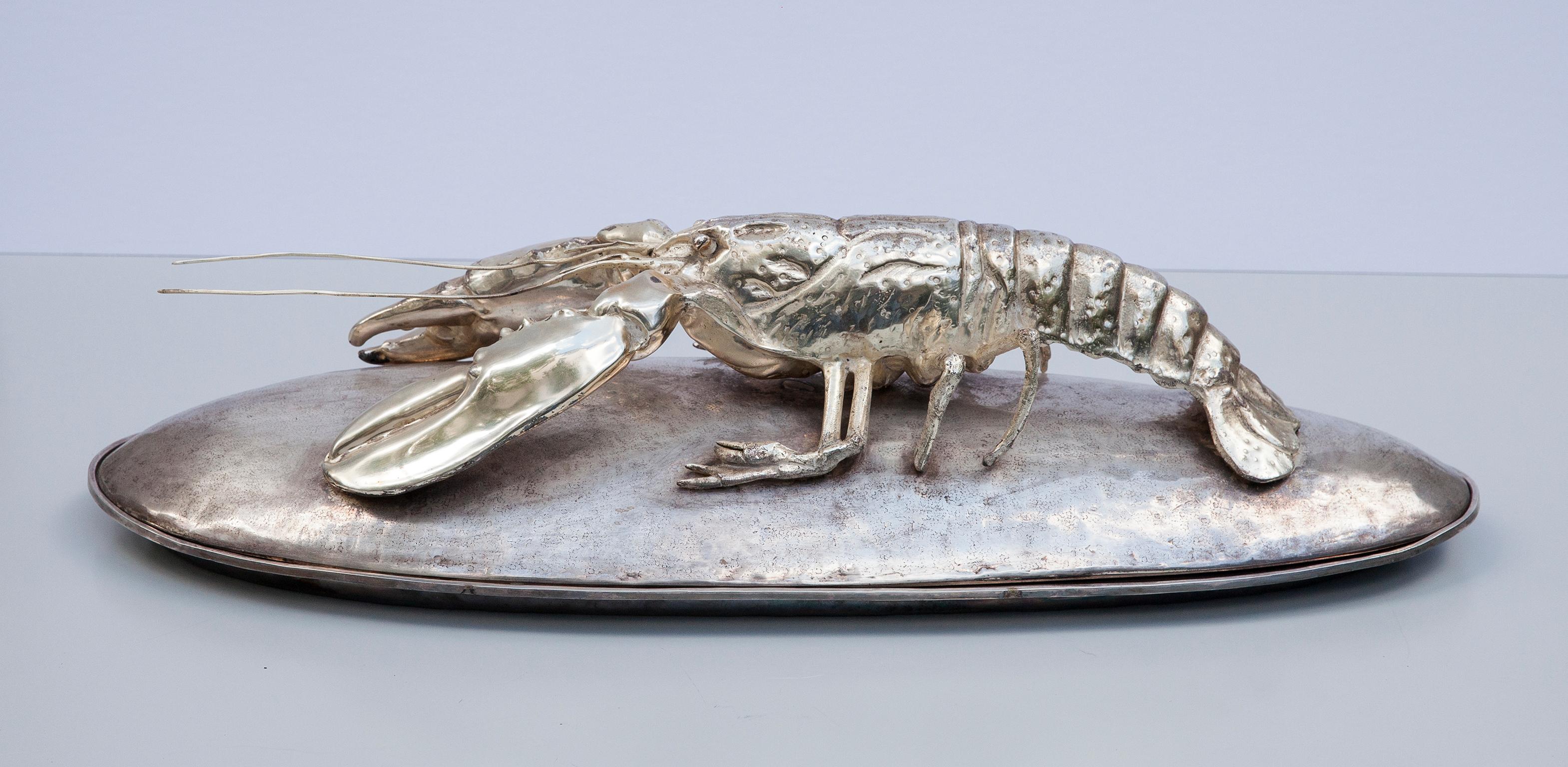 An impressive silver plated covered lobster serving platter by Franco Lapini, Italy, 1970. The large deep oval tray with wide hammered edge, fitted with a conforming hammered lid surmounted a life-like cast lobster, all silver plated on brass.