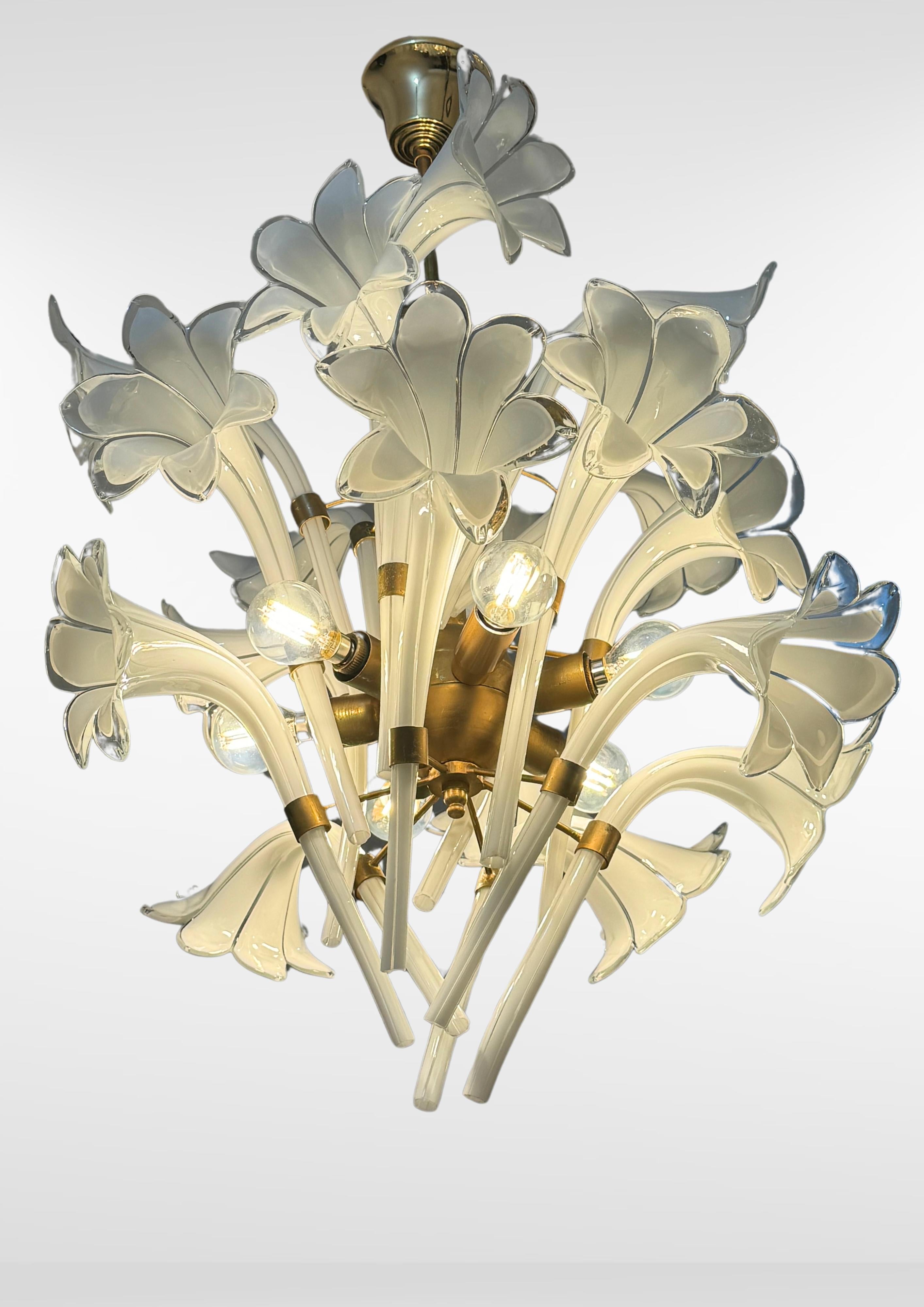 Lampadario in vetro di Murano della metà del secolo scorso di Franco Luce, circa anni '70.
Squisito lampadario in vetro bianco.
Composto da 18 flauti di giglio in vetro soffiato di Murano sospesi su scheletro in metallo dorato Si adatta alla maggior