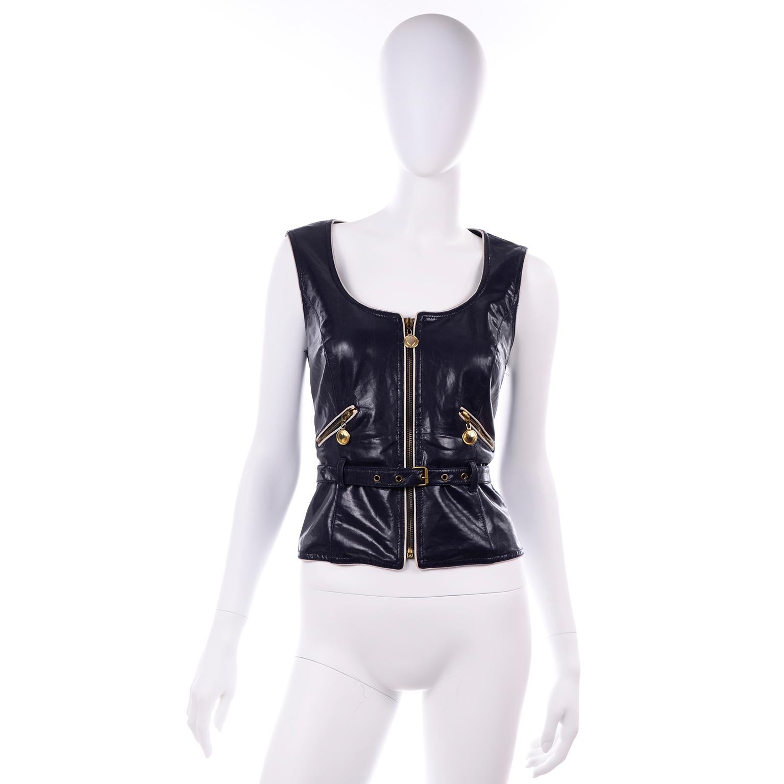 This is a wonderful vintage navy blue faux leather vest with white piping and gold hardware from Moschino Jeans. This collectible designer piece was made in Italy in the early 1990's.  There are two zip slash pockets on the front and a center zipper
