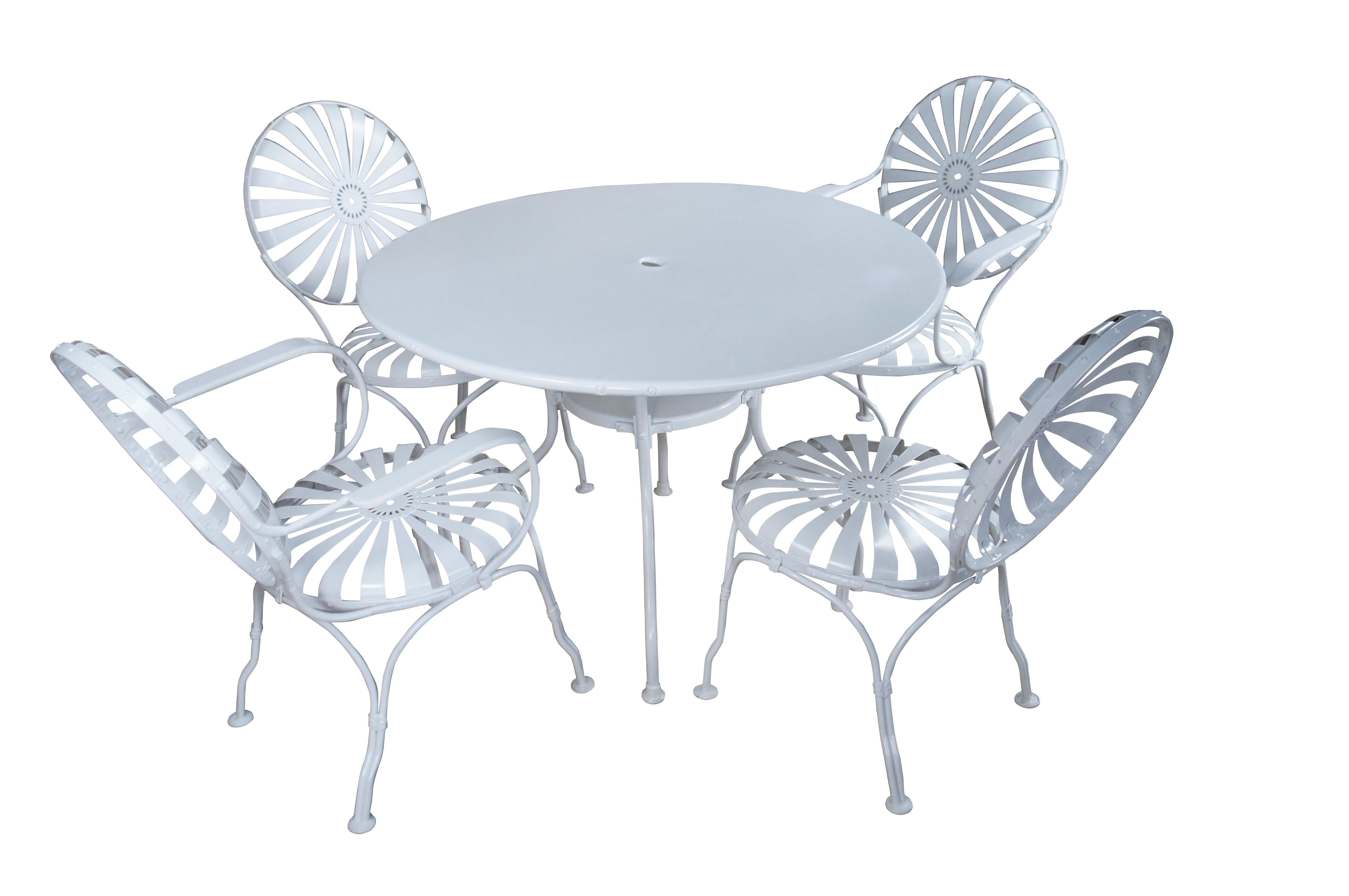 Beautiful Francois Carré Art Deco dining set, circa 1930s.  Features four chairs with a metal frame with sunburst design.  Table is round with hole in the center for umbrella.  Underside of table has latches for purses or bags to hang. Two arm