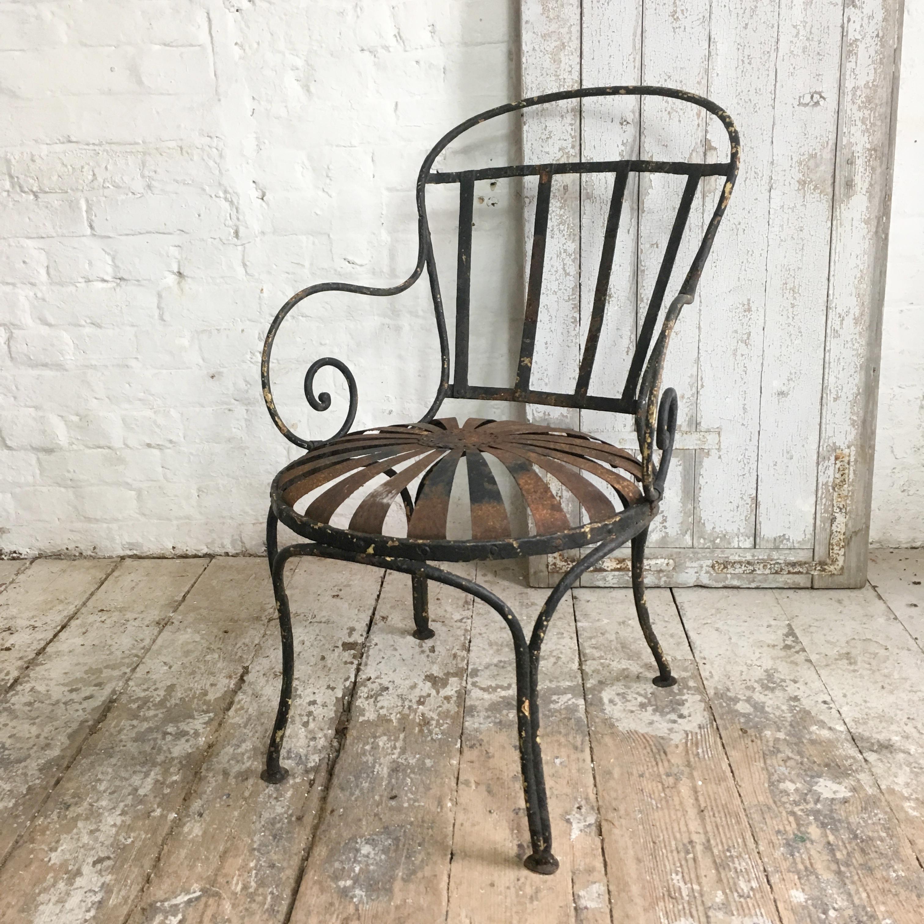 An early 20th century French iron sprung sunburst garden chair by Francois Carre. The chair is black with some areas of light rust and earlier underlying yellow tones of paint showing through, circa 1920s.
Measures: 83cm height, 54cm width, 69cm