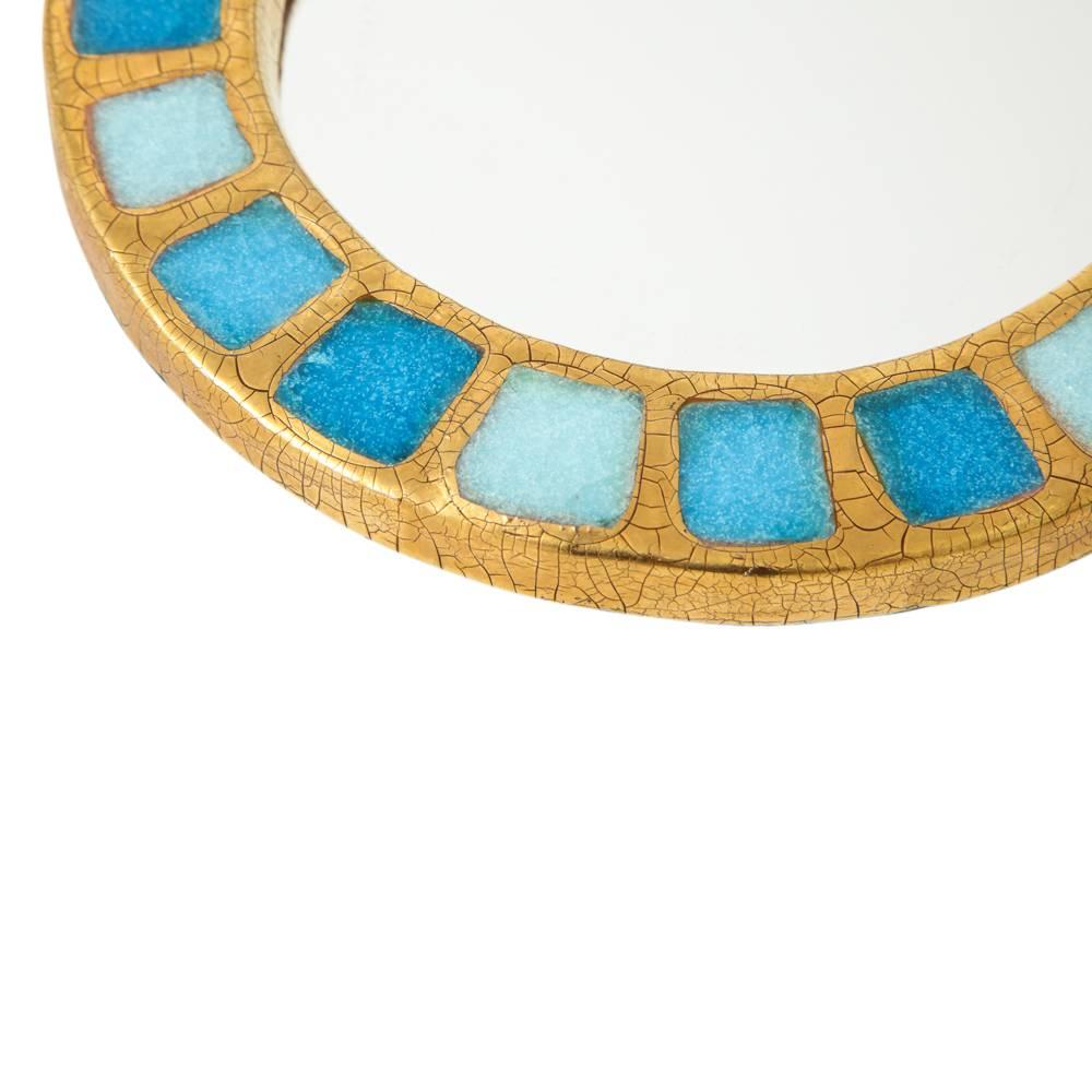 Miroir Mithé Espelt, céramique, verre fusionné or et bleu. Miroir rond à petite échelle en glaçure dorée craquelée avec des carrés de verre fusionné bleu. Dos en feutre.

  