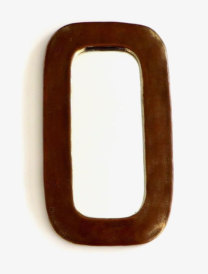 Mithé Espelt handmade mirror with a burnt caramel gold ceramic crackle glaze and gold edging on the outside edge and inside edge towards the mirror, France, 1970s. Each mirror is a piece unique.
In very good original condition with felt