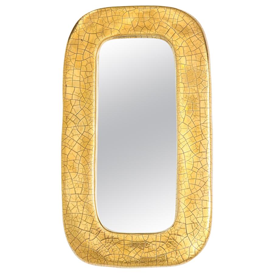 Mithé Espelt mirror, ceramic gold. Small scale gold crackle glazed ceramic wall mirror with oblong form. The verso is covered with green felt.