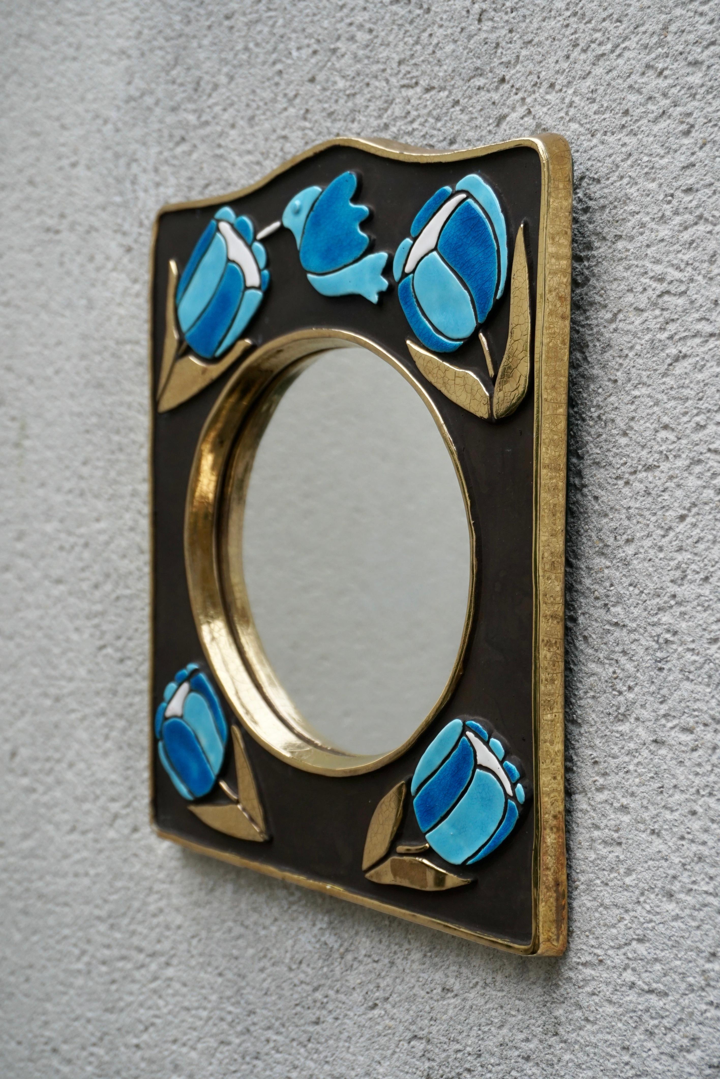 An exceptionally charming mirror in the style of  French ceramicist, Francois Lembo. 
Lembo loved to use birds , jewels and flowers in his designs. These beautiful bird with flowers are set within a gold outline, surrounded by a deep black