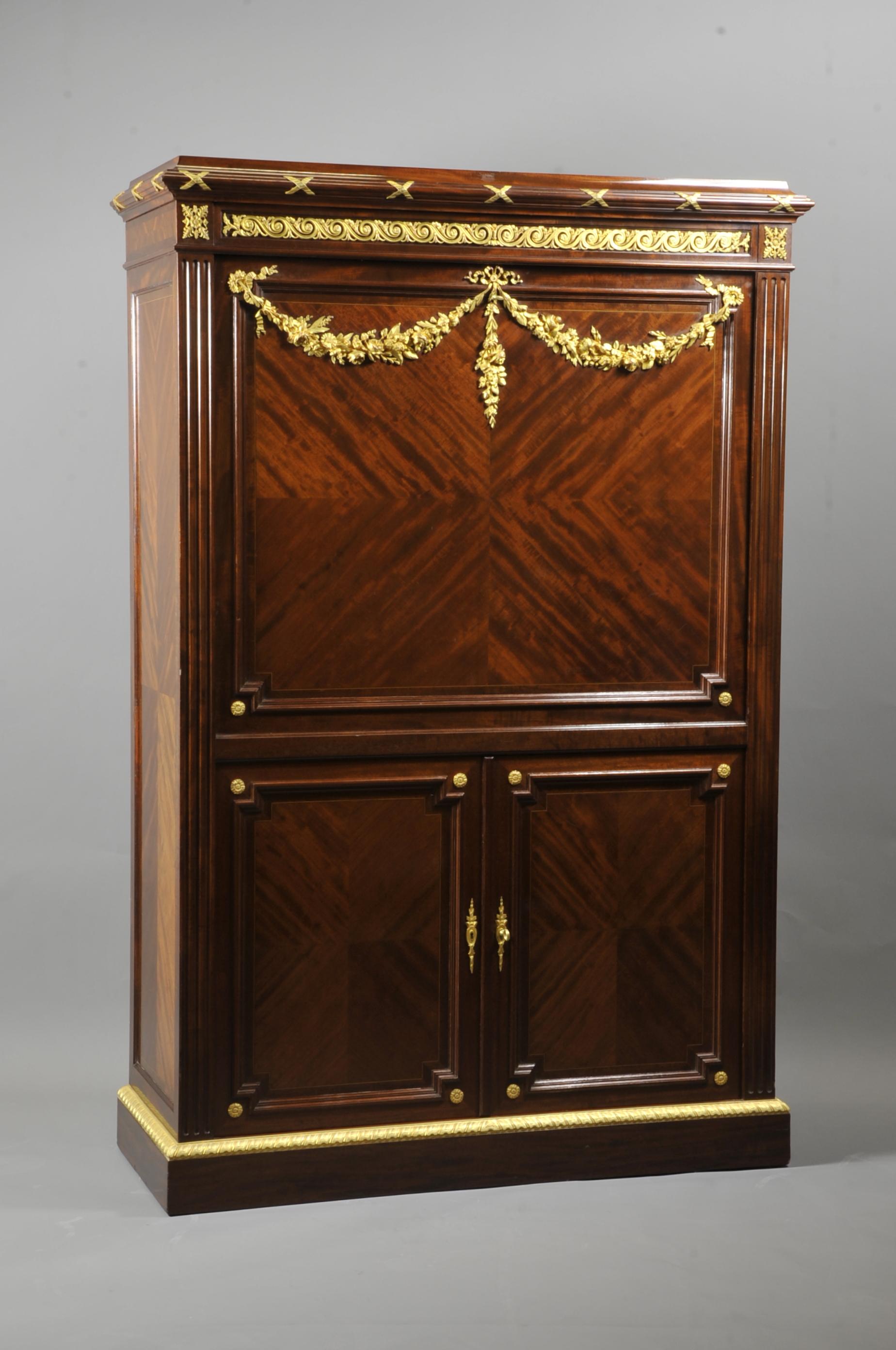 Large Louis XVI style secretaire in mahogany marquetry in frames of light wood and ebony fillets, rich ornamentation of very finely chiseled gilt bronze such as flower garlands, interlacing friezes and gadroons, braces and masks.

Mounted on a