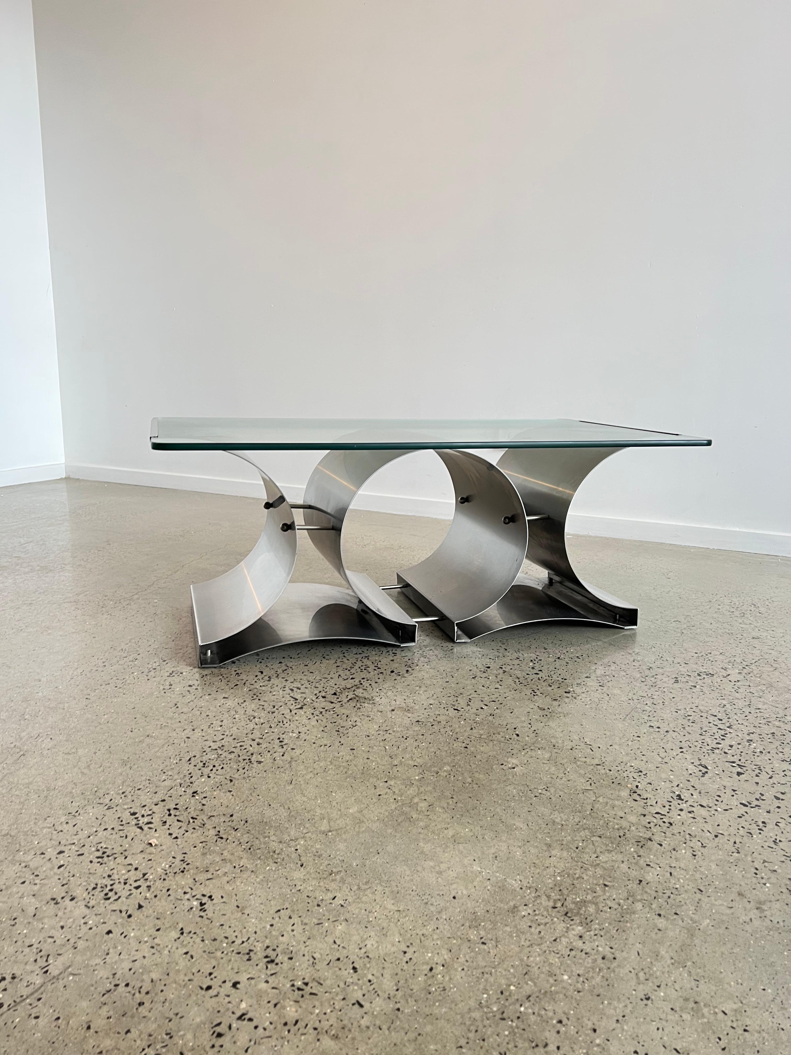 Space Age vintage coffee table or sofa table from stainless steel and clear glass designed by Francois Monnet for Kappa.
France, circa 1970.
This sleek and futuristic design shows a stainless steel construction with a clear glass plate, which is