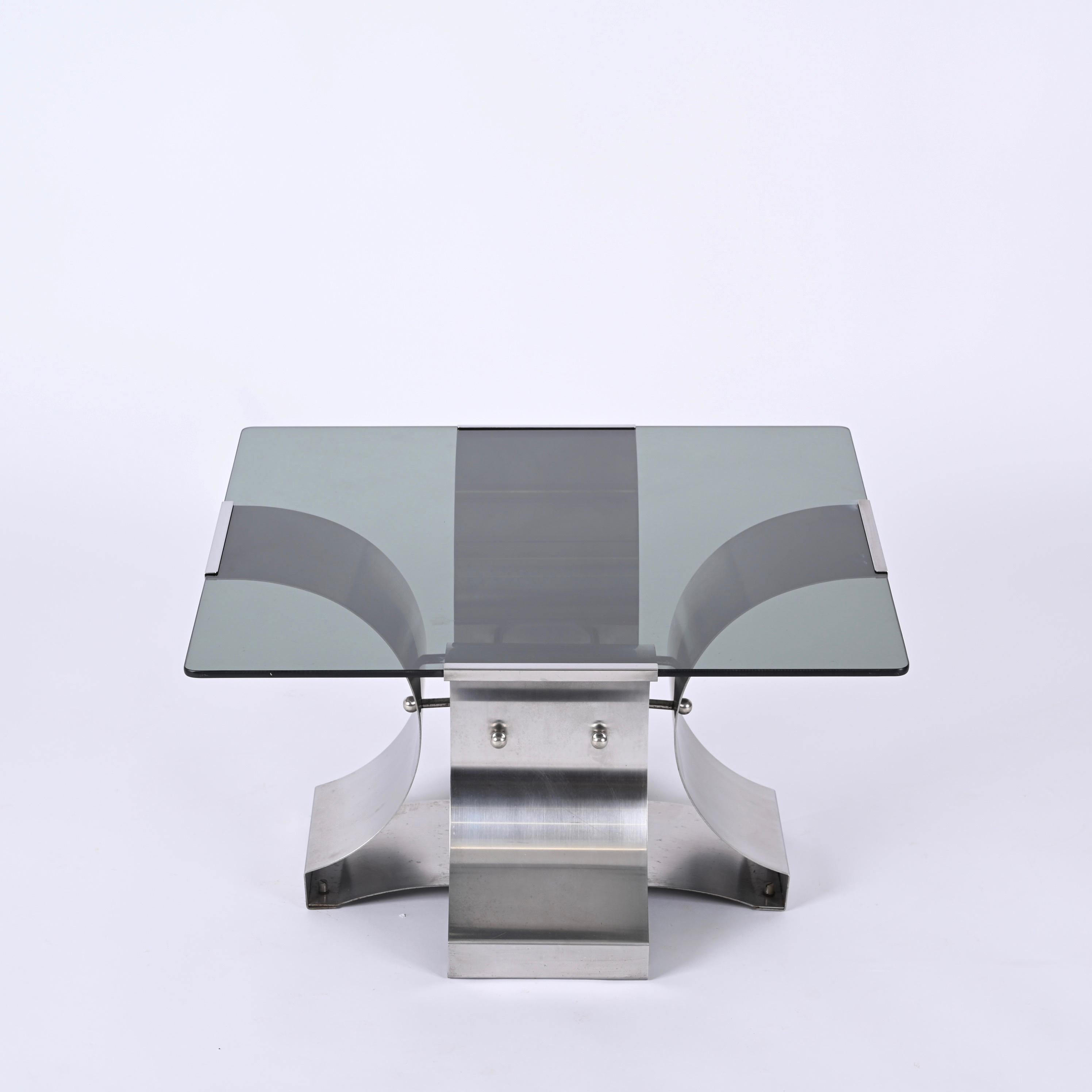 Gorgeous midcentury smoked glass and brushed stainless steel square coffee table. This beautiful piece was designed by Francois Monnet in France during 1970s.

This high-quality table is made of an elegant brushed and curved stainless steel; the