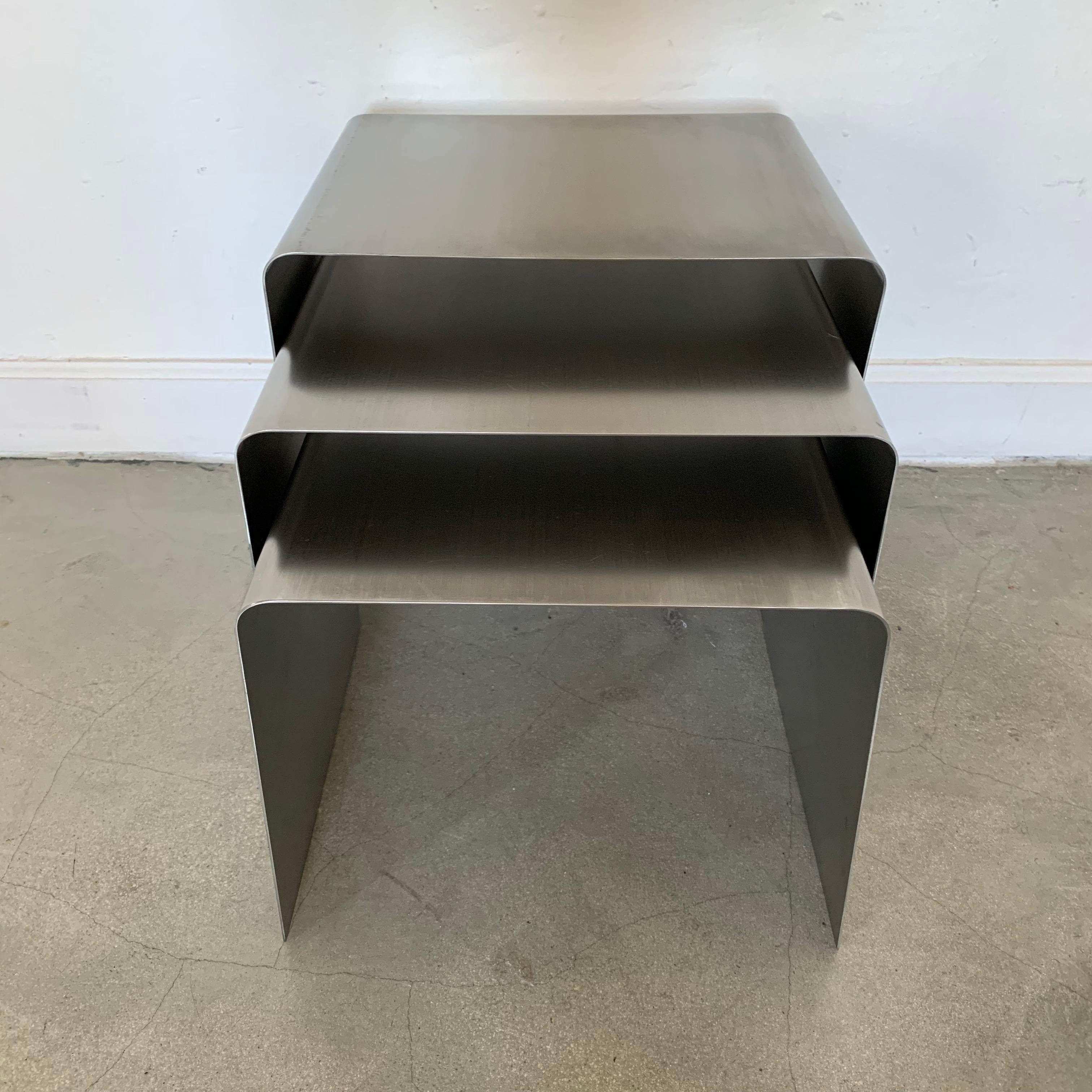 Rare set of three nesting tables rendered in bent brushed stainless steel designed by François Monnet for Kappa, France, 1970s.

Table Sizes:
Large- 13 D x 15.75 W x 15.5 H
Medium- 13 D x 15 W x 13.75 H
Small- 13 D x 13.5 W x 11.5 H.