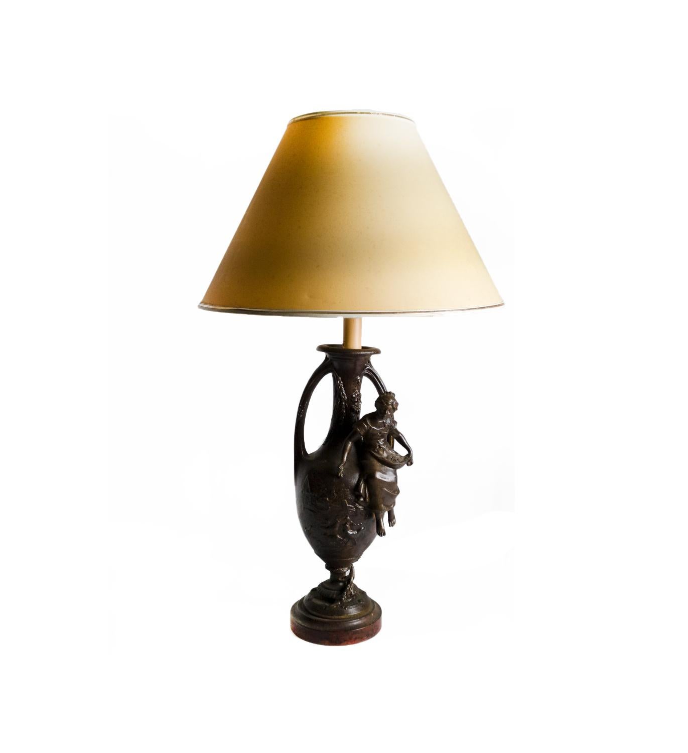 A  metal table lamp amphora letterhead with women's embossing and wood base signed «F. Moreau».
Does not include lampshade.
