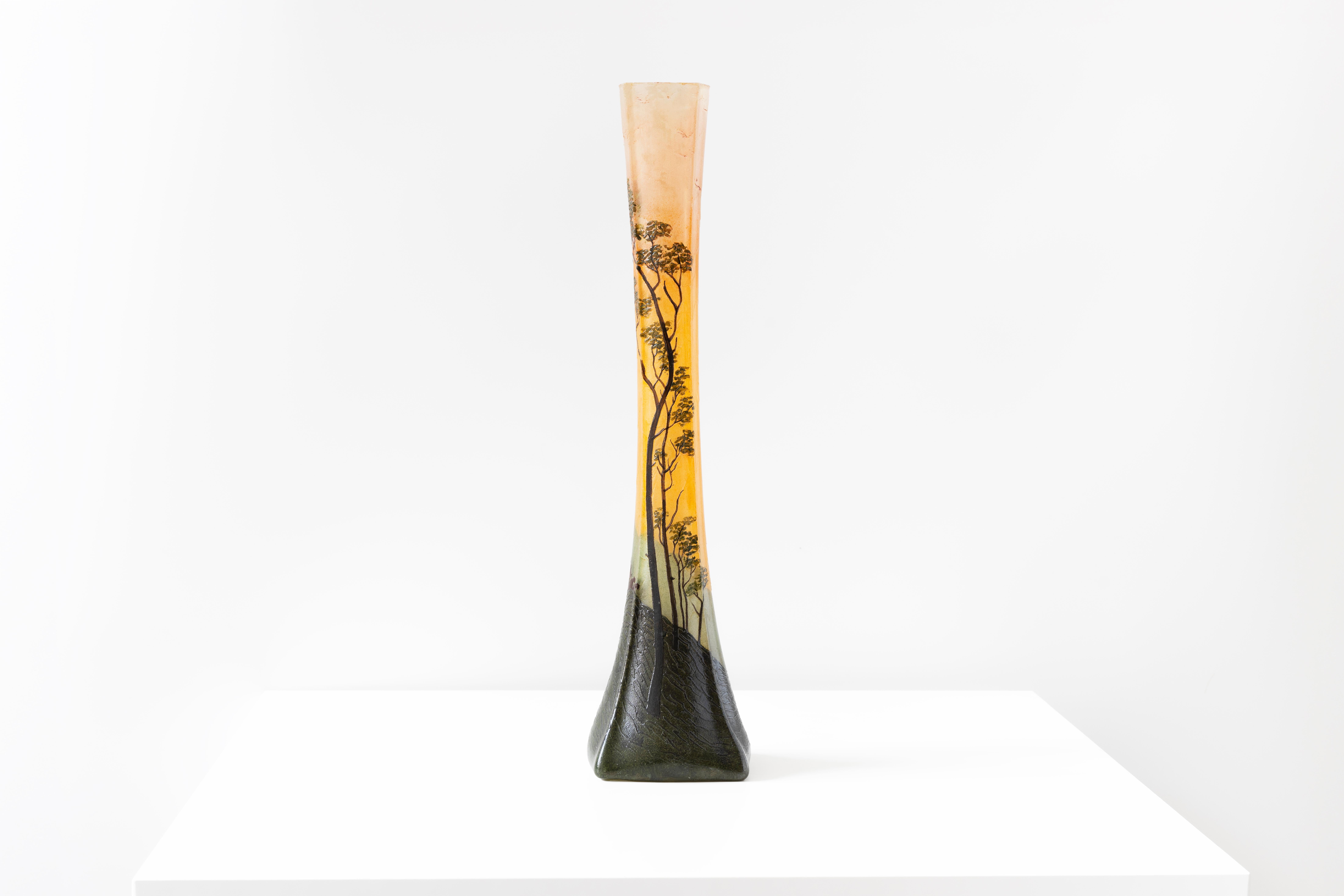 Ce vase Soliflores de François-Théodore Elegs capture l'essence de la nature avec sa silhouette élégante et allongée. L'impression industrielle du verre orange et vert crée une toile de fond captivante pour les silhouettes complexes d'arbres avec un