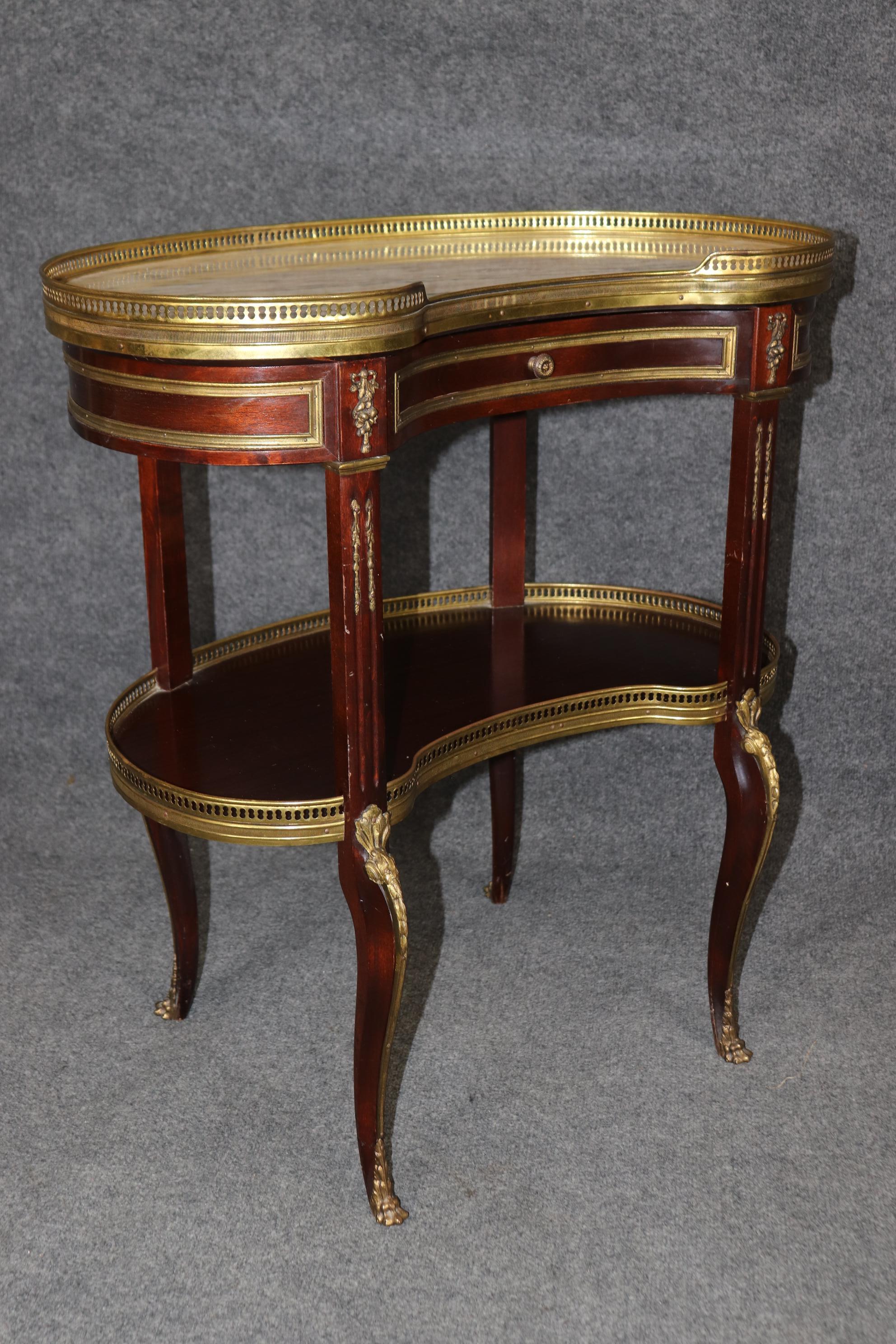 This is a superb, absolutely spectacular pair of end tables with some of the finest bronze Dore' gold finished bronze and superb marble top. The frames are made of solid mahogany and designed in a very sophisticated kidney shape. These are in good