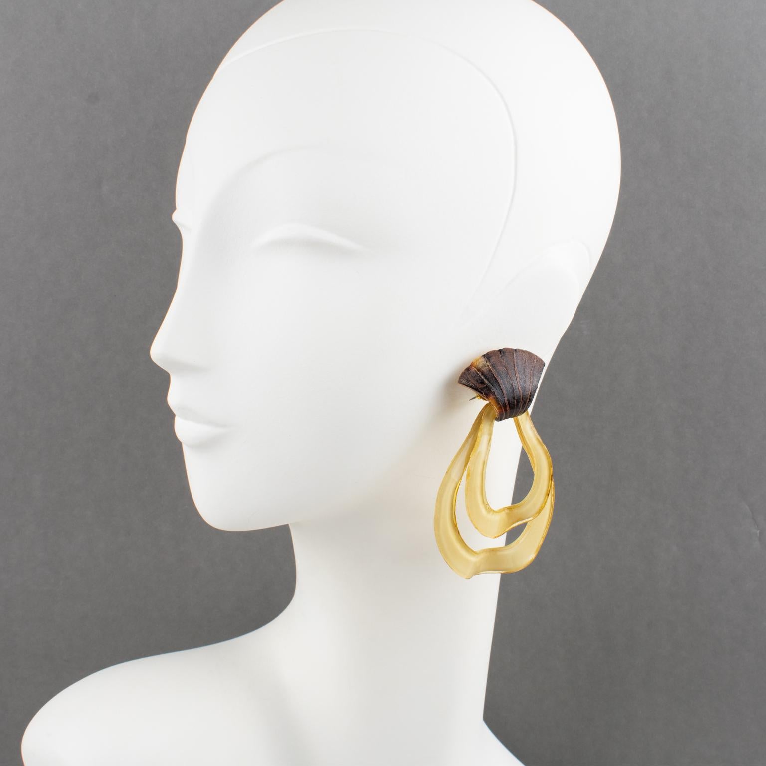 Cilea Paris designed these cute clip-on earrings for French designer Francoise Montague. The pieces boast a massive dangle shape in tan beige colored resin in graduated pear-shaped drops with tortoise resin triangle fastenings. The assorted carved