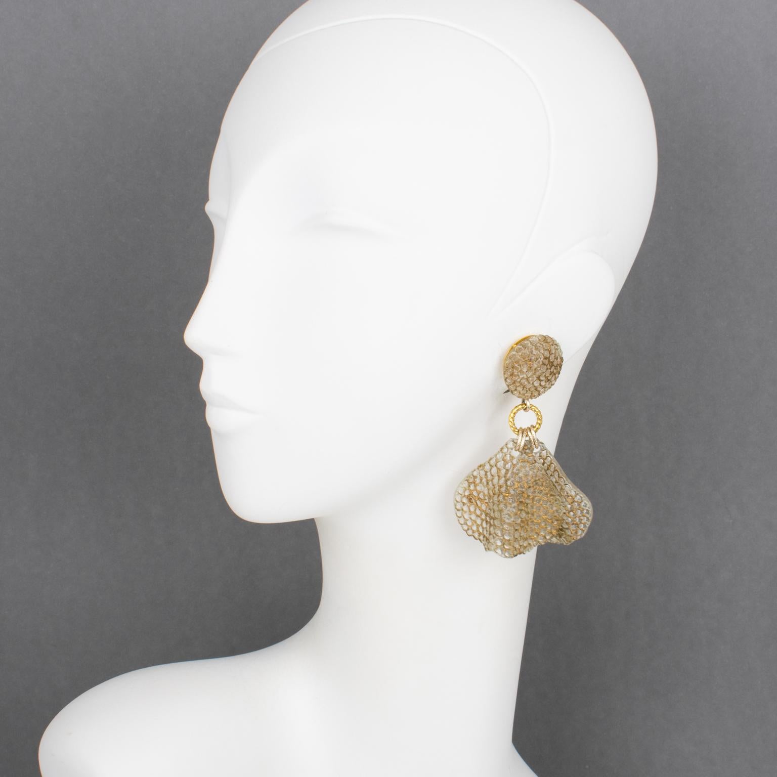 These gorgeous Francoise Montague Paris clip-on earrings, designed by Cilea Paris, feature an oversized dangle shape in translucent resin with dimensional waved and honeycomb textured petals embellished with gold application. The earrings are built