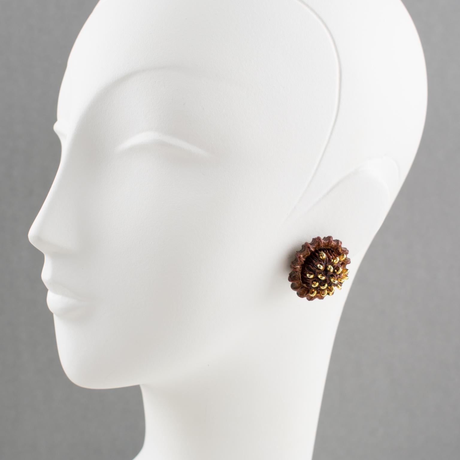 French jewelry designer Francoise Montague Paris hand-crafted these lovely clip-on earrings in the 1980s. The round domed shape boasts a cocoa brown resin with a stylized flower ornate with tiny brass studs. There is no visible signature like all