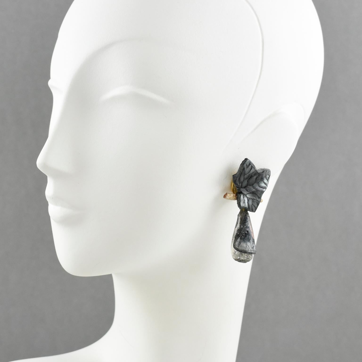 These lovely French jewelry designer Francoise Montague Paris clip-on earrings are from the 1990s. They feature a massive dangle shape, in resin, with a dimensional carved leaf and a teardrop bead. These pieces boast elegant assorted fall colors, in