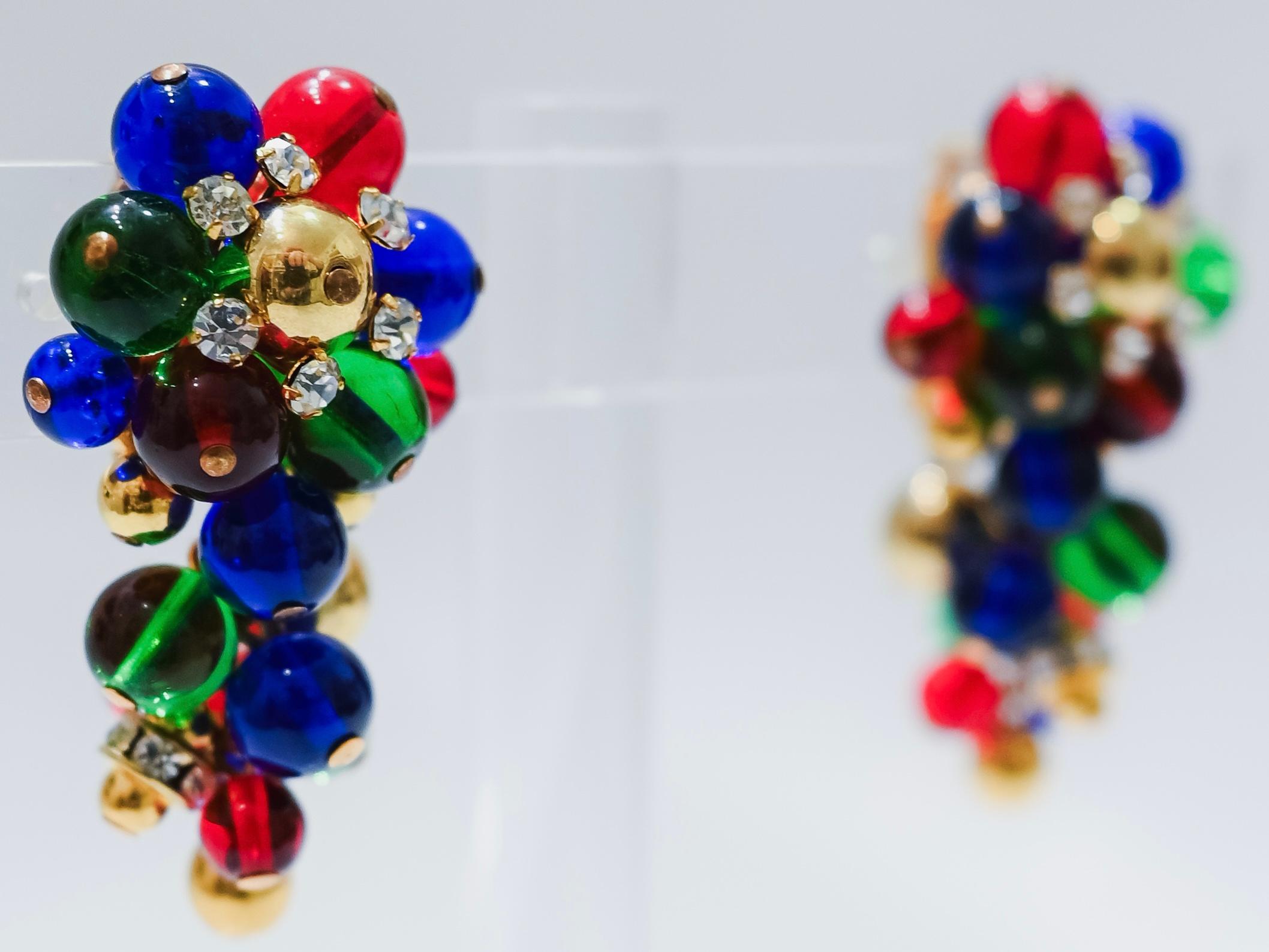 Green and gold glass clip earrings inspired after a bunch of grapes from French design house Francoise Montague. 
Francoise Montague took over the De Saurma jewelry workshop in the late 1940s. Her mother founded the workshop in 1945, according to