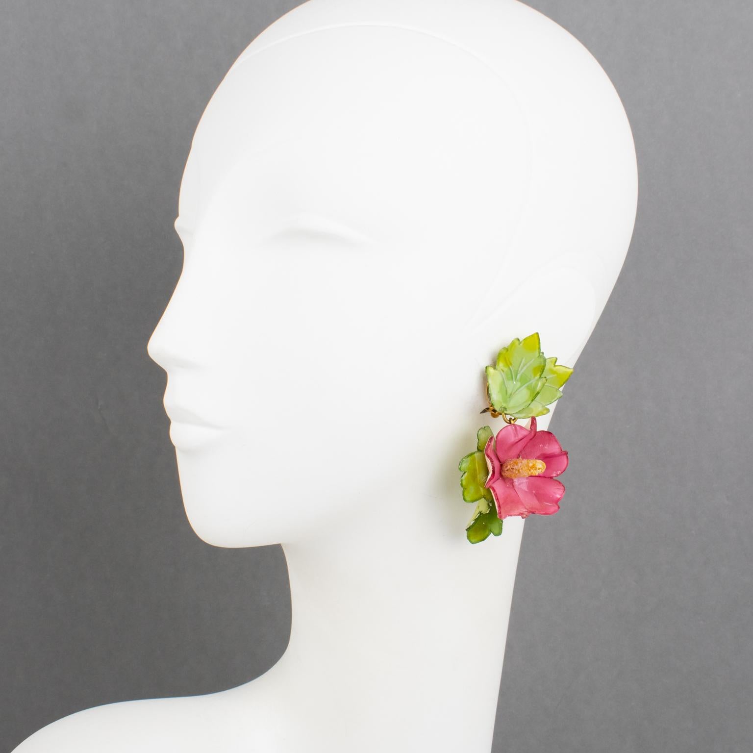 Cilea Paris designed these adorable resin clip-on earrings for French jewelry designer Francoise Montague. The dangle shape features a dimensional hibiscus flower with leaves. The pieces boast powder pink and green colors. There is no visible