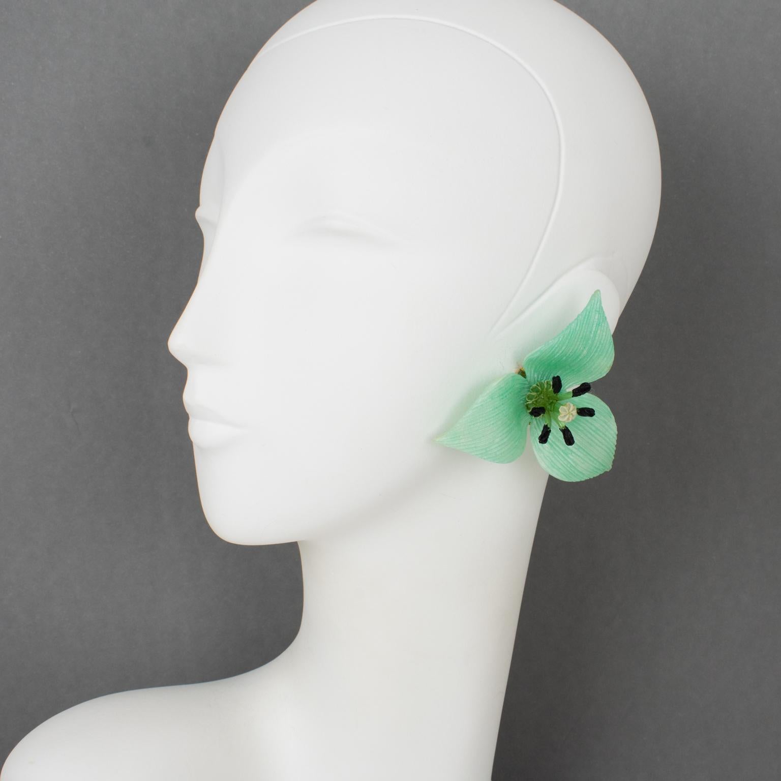 French Jewelry Designer Francoise Montague Paris designed these stunning oversized resin clip-on earrings. The dimensional flower shape boasts light turquoise resin petals with a textured pattern contrasted with a black and white colored resin