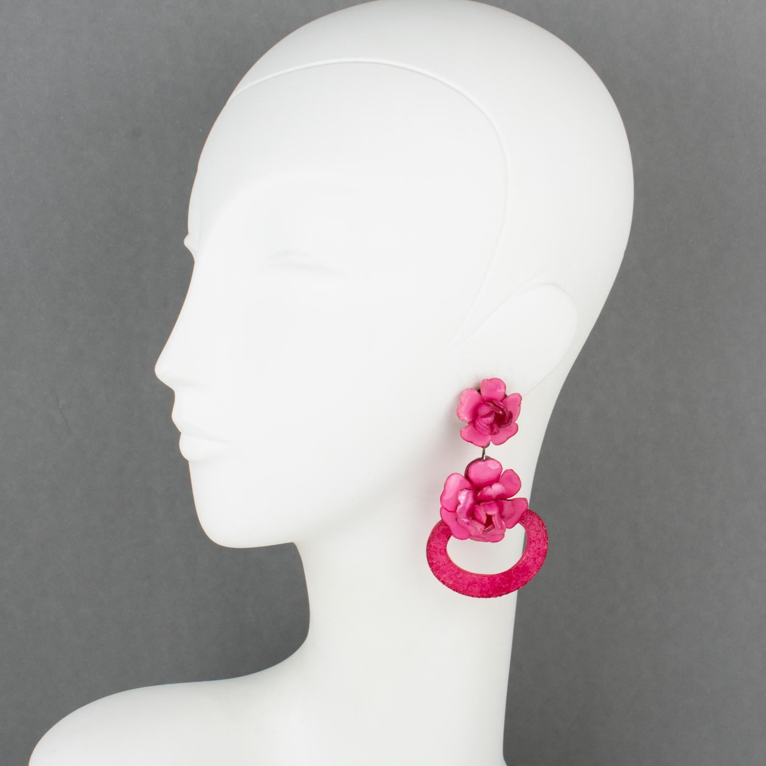 These clip-on earrings by Cilea Paris for designer Francoise Montague are stunning. The pieces feature a dimensional hand-made dangle-drop shape in fuchsia pink-colored resin shaped as rose flowers. The assorted carved and textured patterns are used