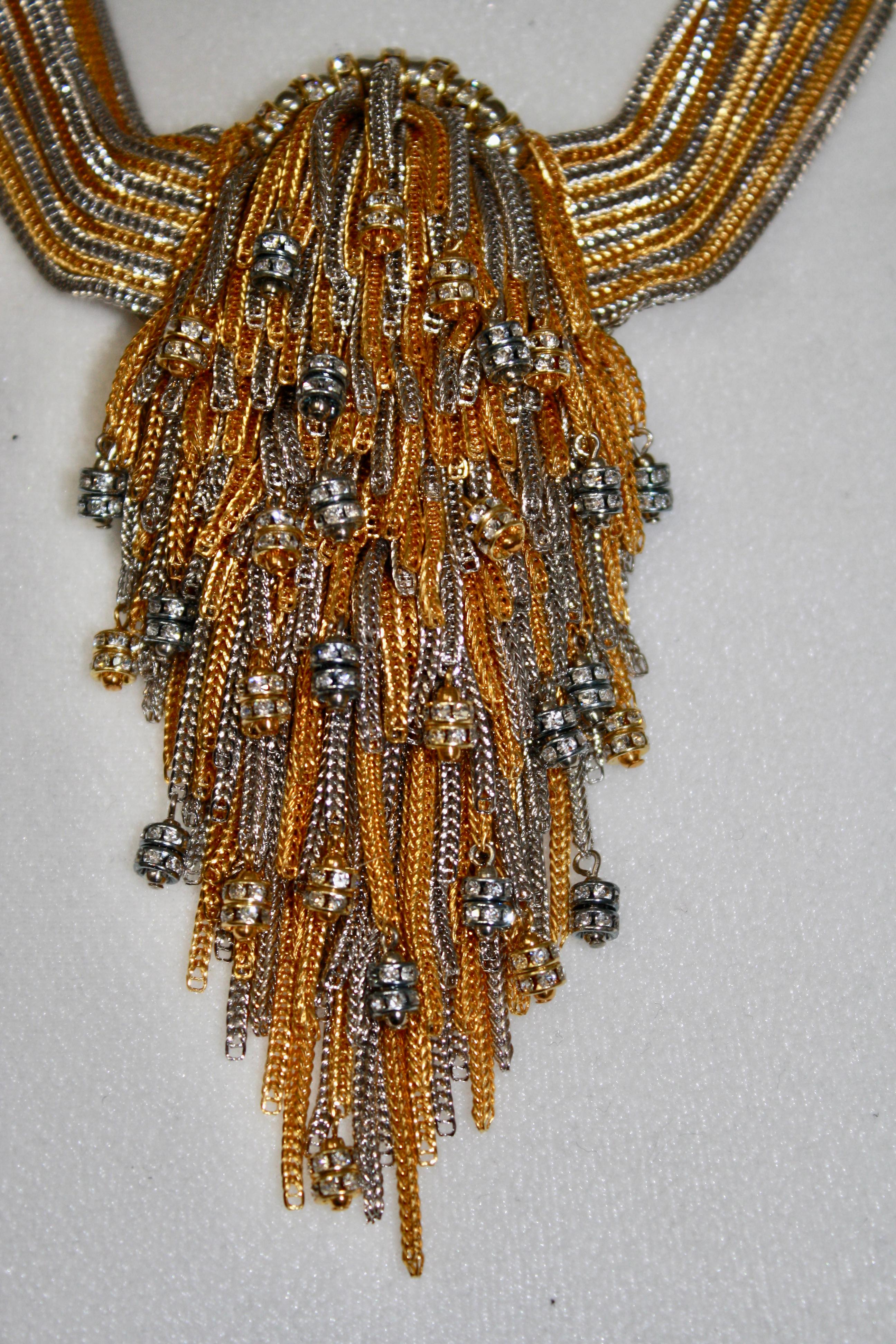 14 strands of gold and silver chains with center short tassel finished with Swarovski crystal rondelles.
4