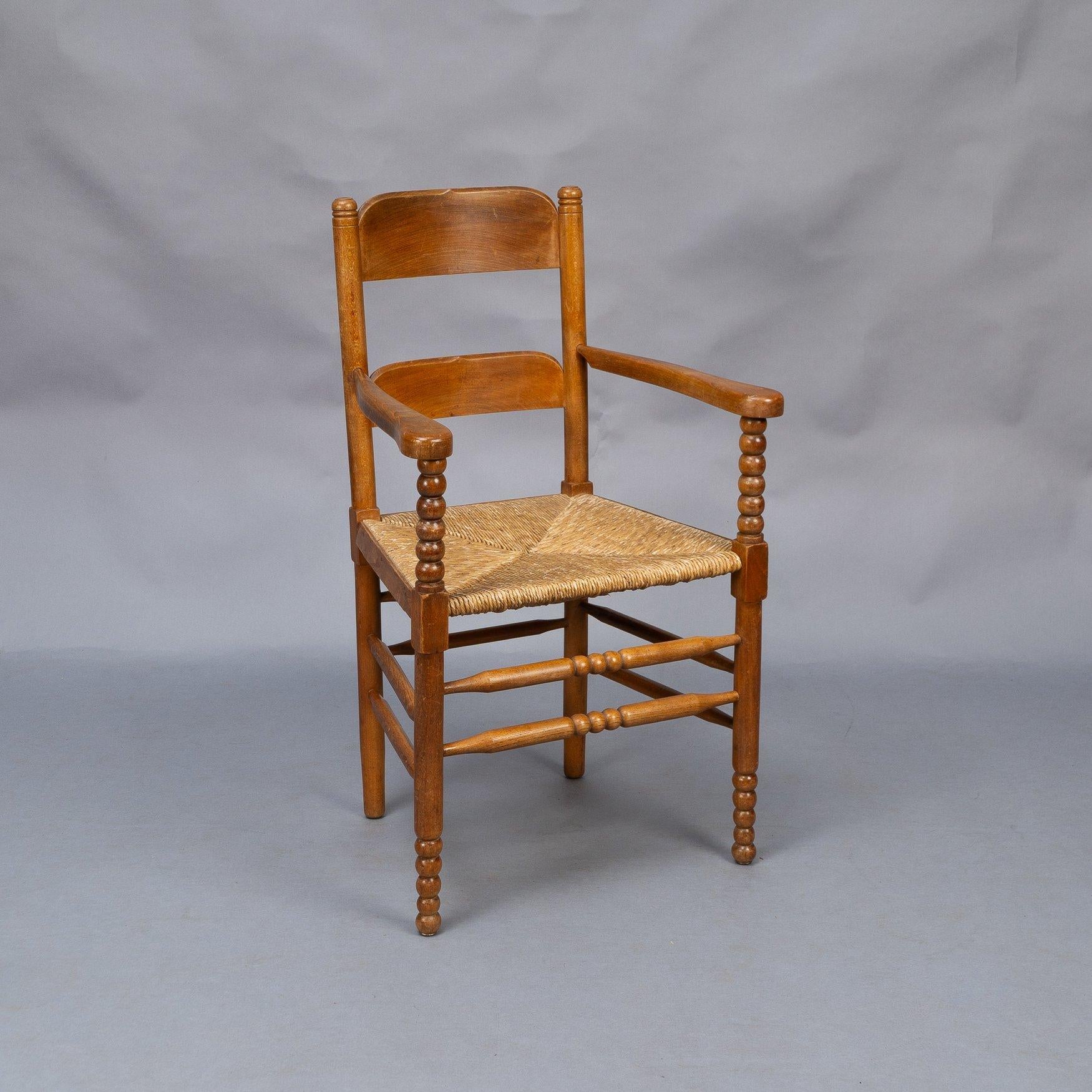 Sessel im Stil von Frank Brangwyn
Armlehnstuhl aus Eichenholz im Cotswold-Stil im Arts-and-Crafts-Stil, mit eingeschnittenen, gedrechselten Endstücken und zwei großen, geformten Rückenlehnen, jede mit einem subtilen, geschnitzten V in der Mitte der