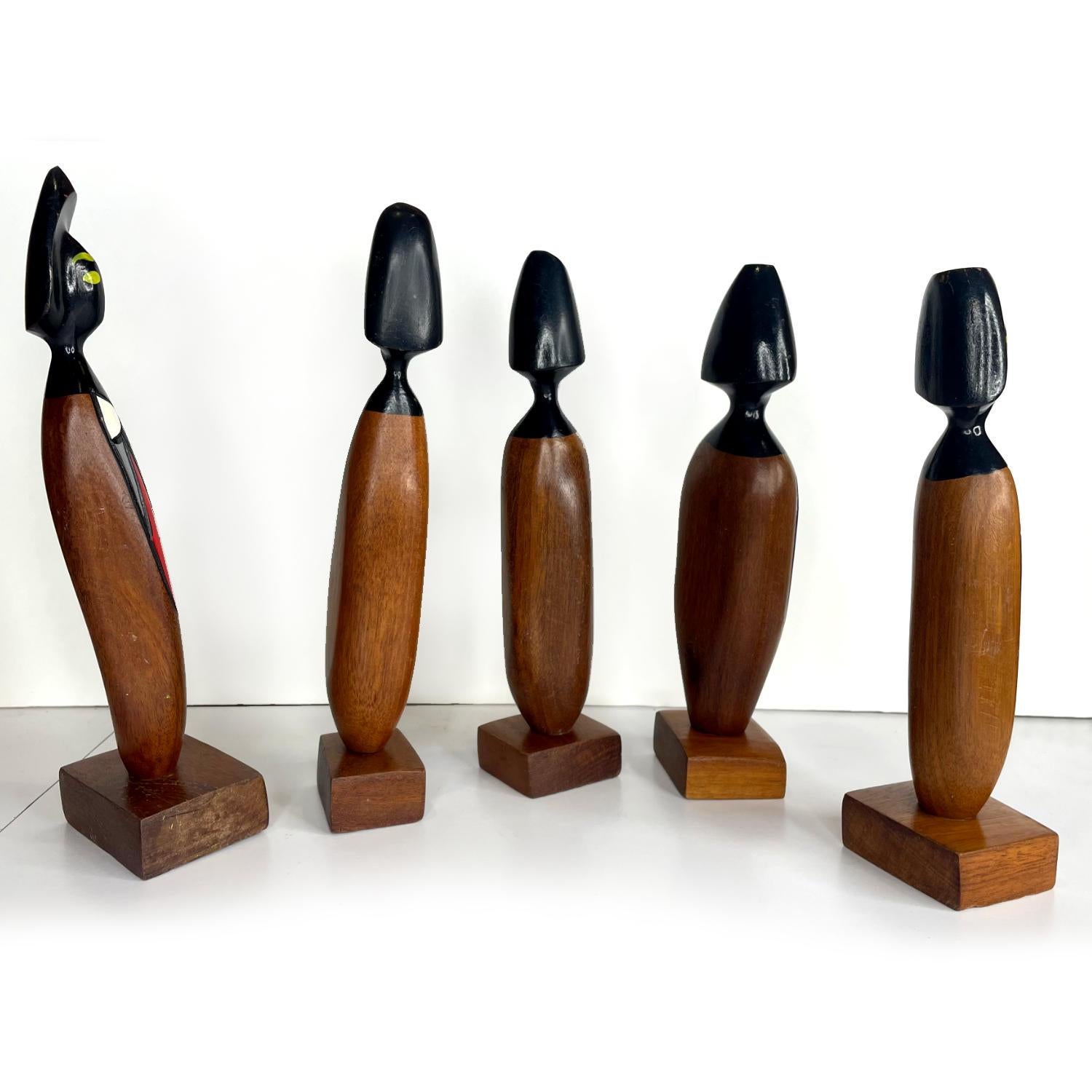 Gruppo di cinque statuette in legno intagliato della metà del secolo scorso dell'artista dominicano Frank Coronado. Ogni figura è dipinta a mano con forme geometriche bianche, rosse, gialle, blu e verdi con contorni neri. Il design si ispira