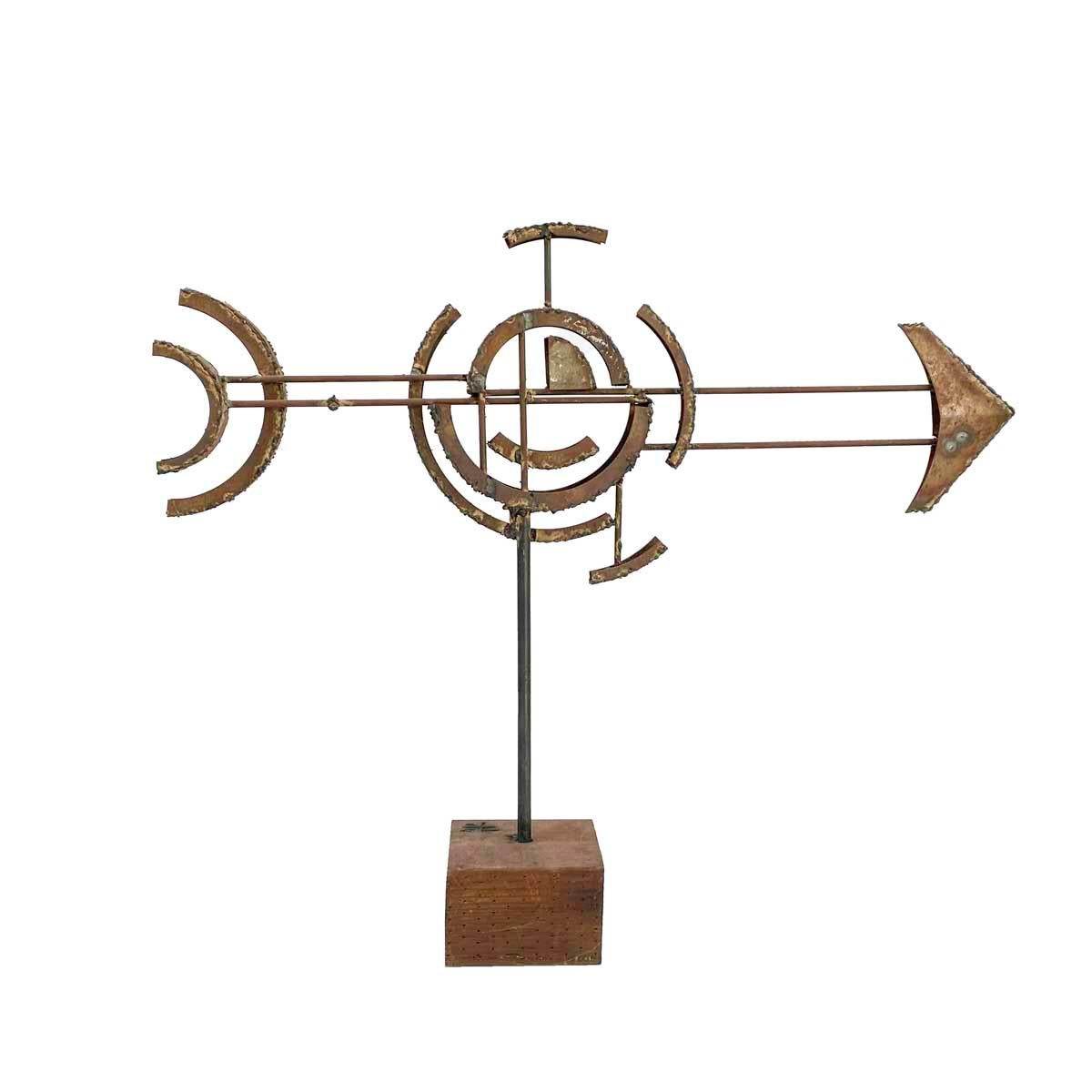 Welded metal sculpture in the Brutalist style by California sculptor Frank Cota and signed FC on the wood base. The sculpture in two dimensions, weathervane-like, of an arrow through a burst sphere.