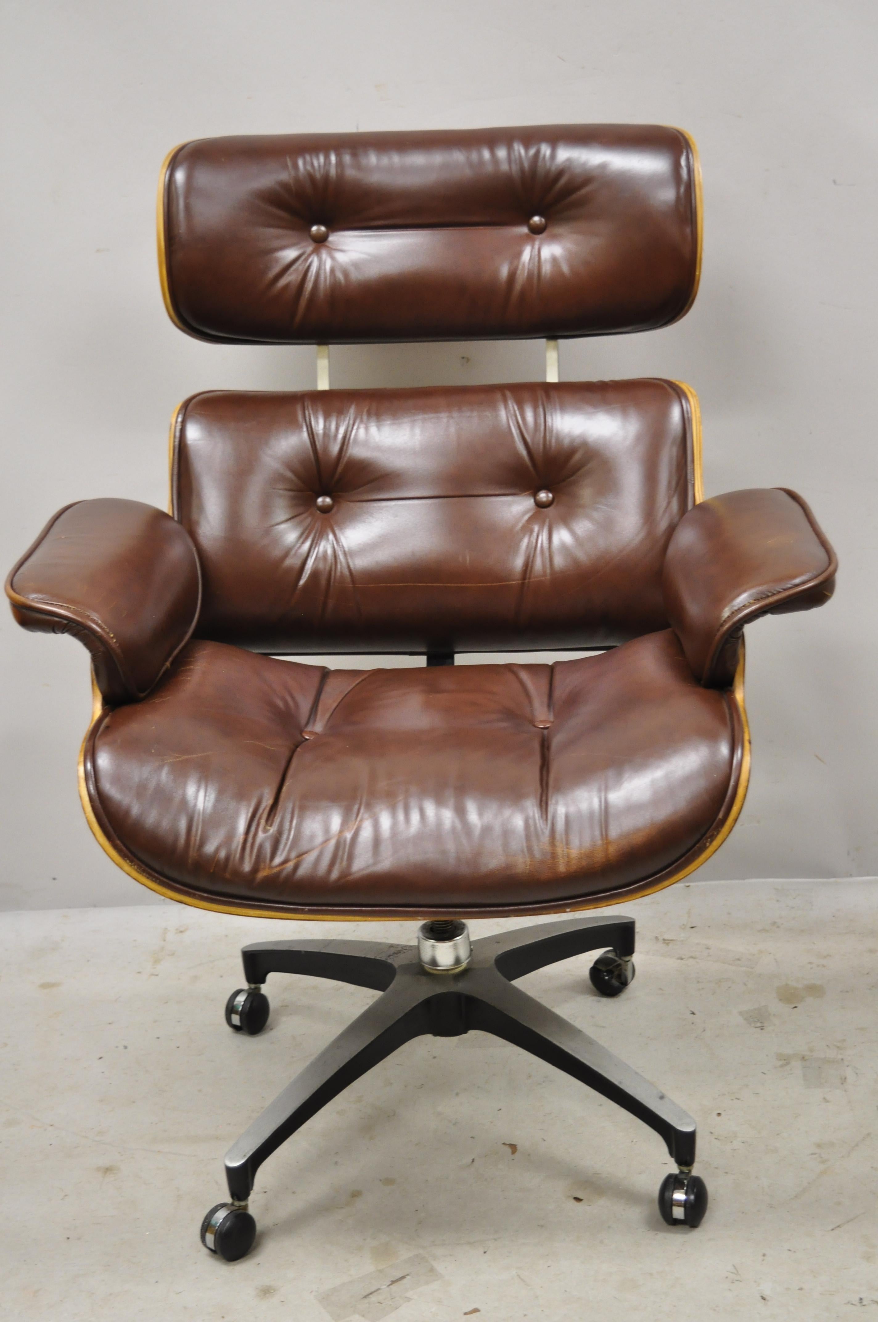 Frank Doerner Eames style brown vinyl rolling swivel office desk lounge chair. Item features rolling casters, tufted upholstery, beautiful wood grain, upholstered armrests, original stamp, clean modernist lines, great style and form. Circa 1975.