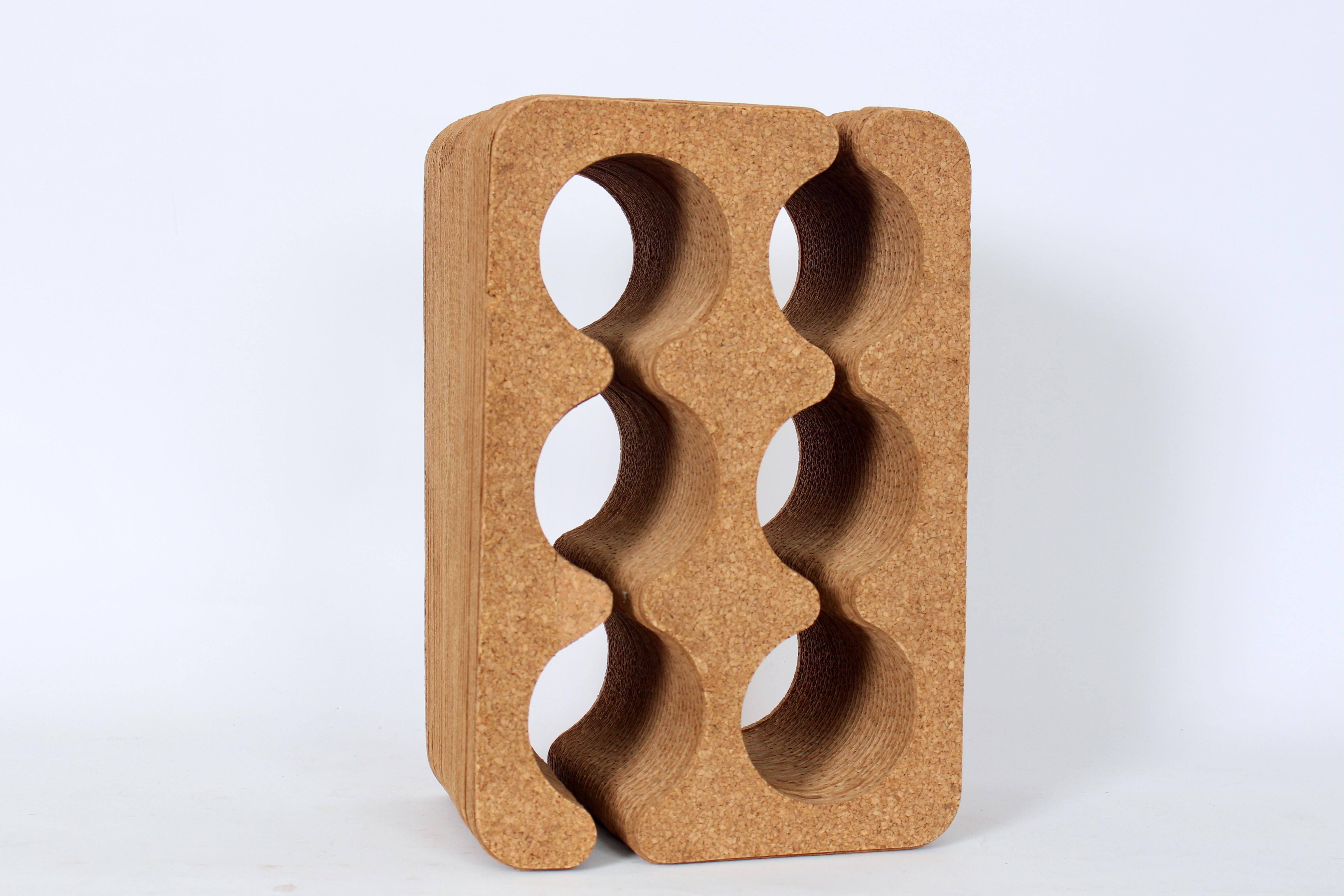 Portabottiglie da 6 bottiglie in sughero e cartone della fine del XX secolo. Alla maniera di Frank Gehry. È caratterizzato da una robusta forma rettangolare in cartone rivestito di sughero con 6 aree per qualsiasi serie di bottiglie da 3,5