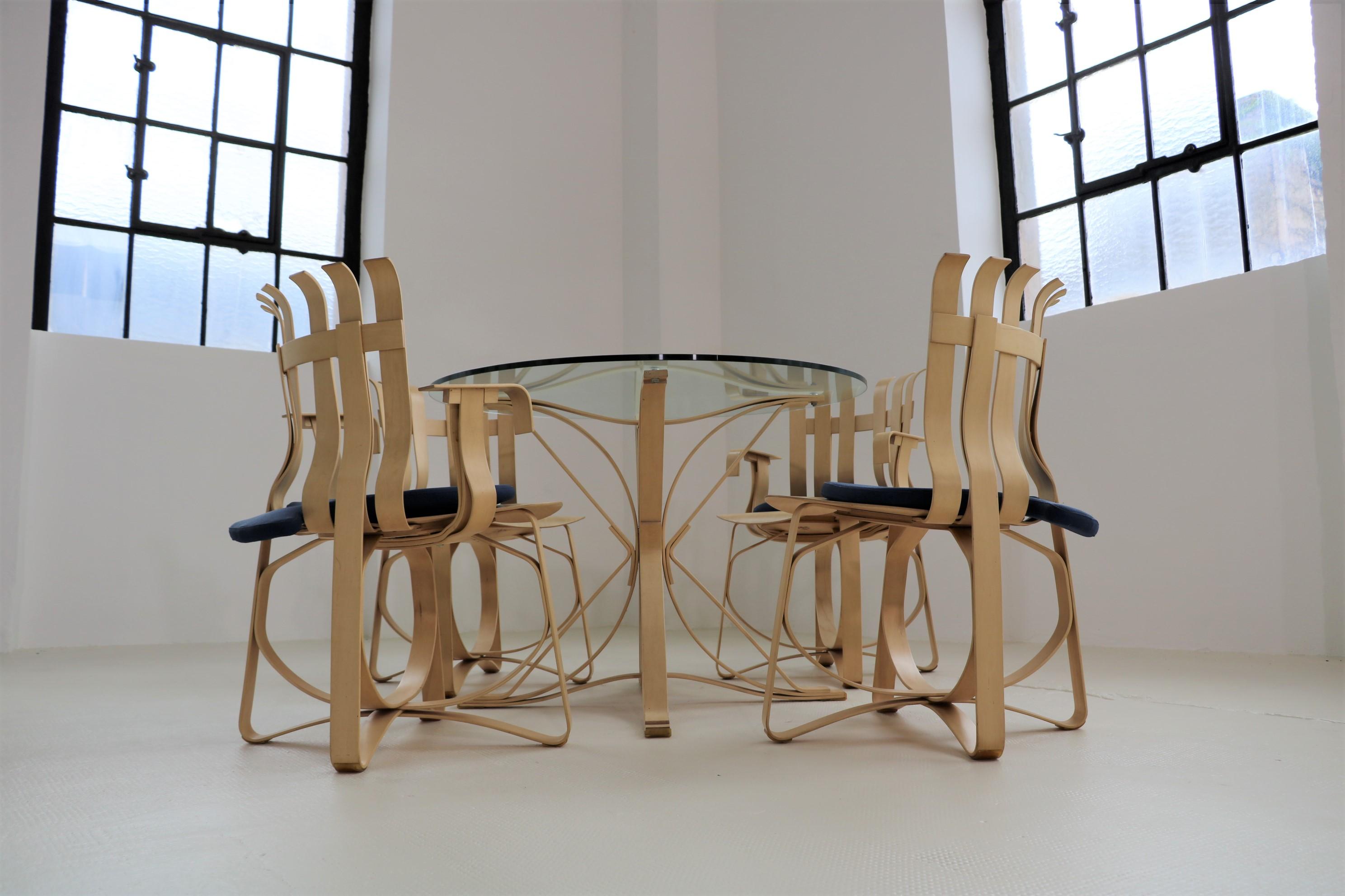 Dining set by Frank Gehry for Knoll International, produced in 1993.
Very nice original condition with matching, original seat pads from Knoll International.
Made from laminated maple wood that is bent, woven and curved into a functional sculpture.