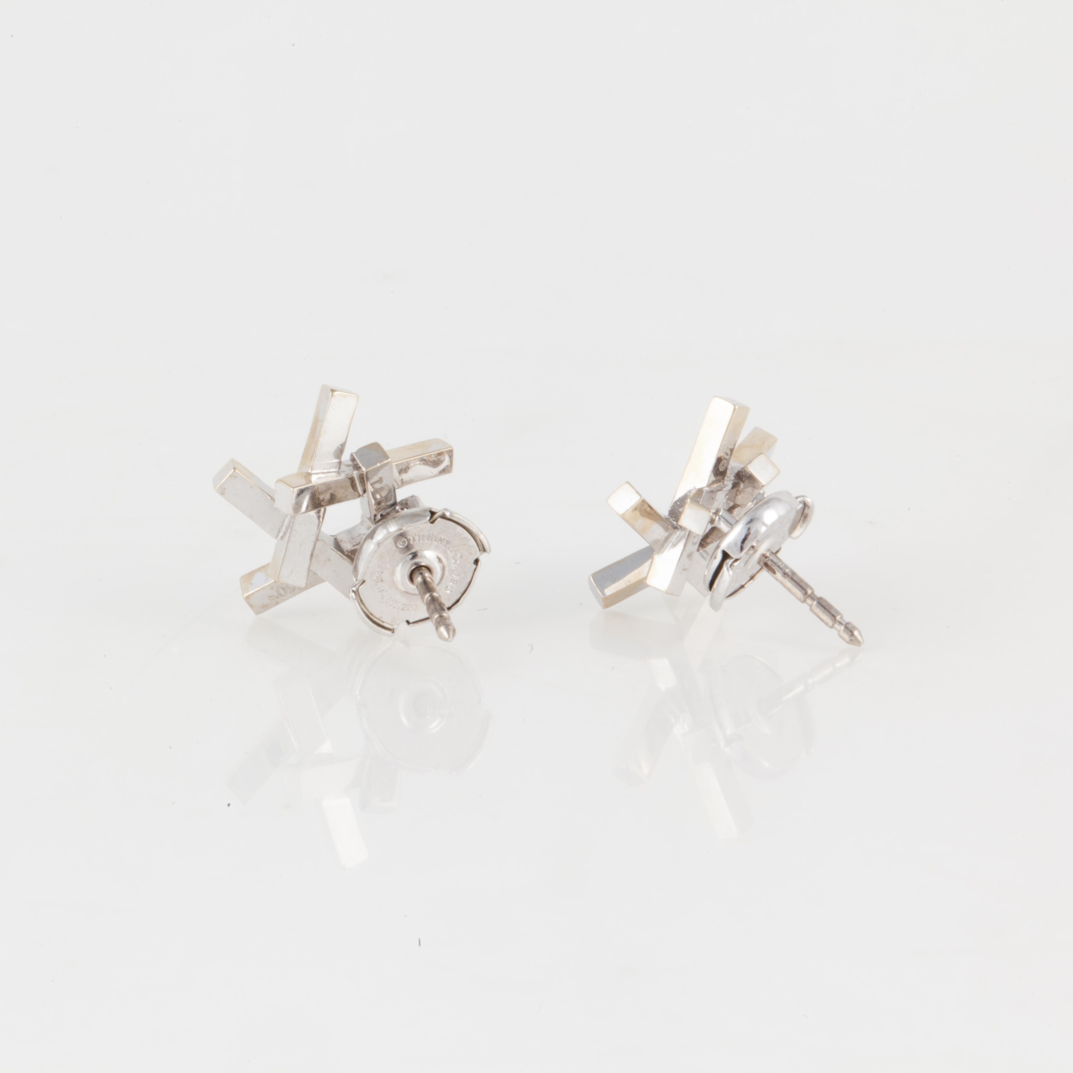 These earrings designed by Frank Gehry for Tiffany & Co. are 18K white gold with diamonds, from the Axis collection.  The earrings feature sixty (60) round diamonds totaling 0.60 carats, E-F color and VVS clarity.  They measure 9/16 inches across
