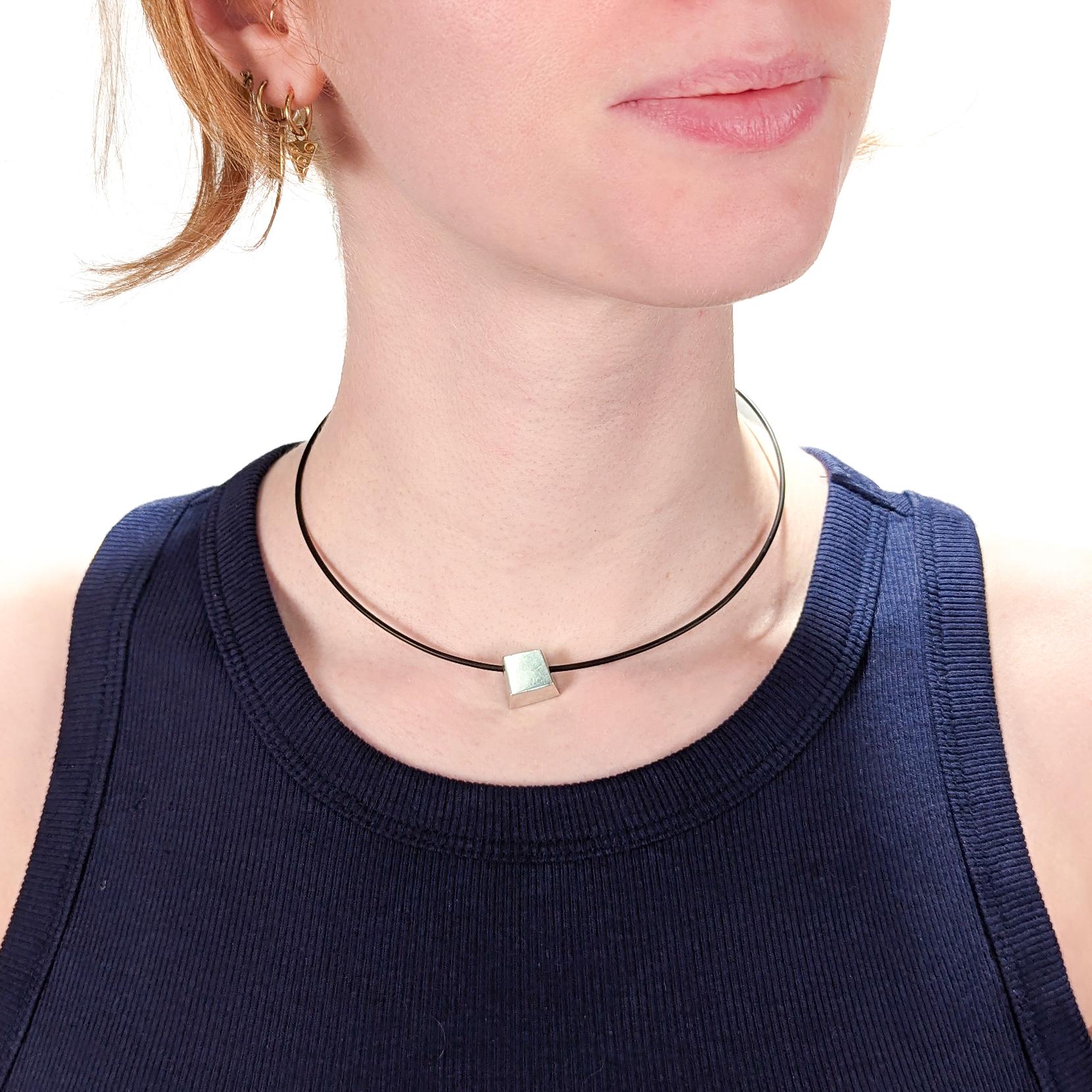 A fine Cube Torque choker necklace.

In sterling silver.

Designed by Frank Gehry for Tiffany & Co.

Suspended from a black cable choker necklace Tiffany & Co. 

Fully hallmarked.

Simply wonderful Tiffany design!

Date:
Late 20th Century

Overall