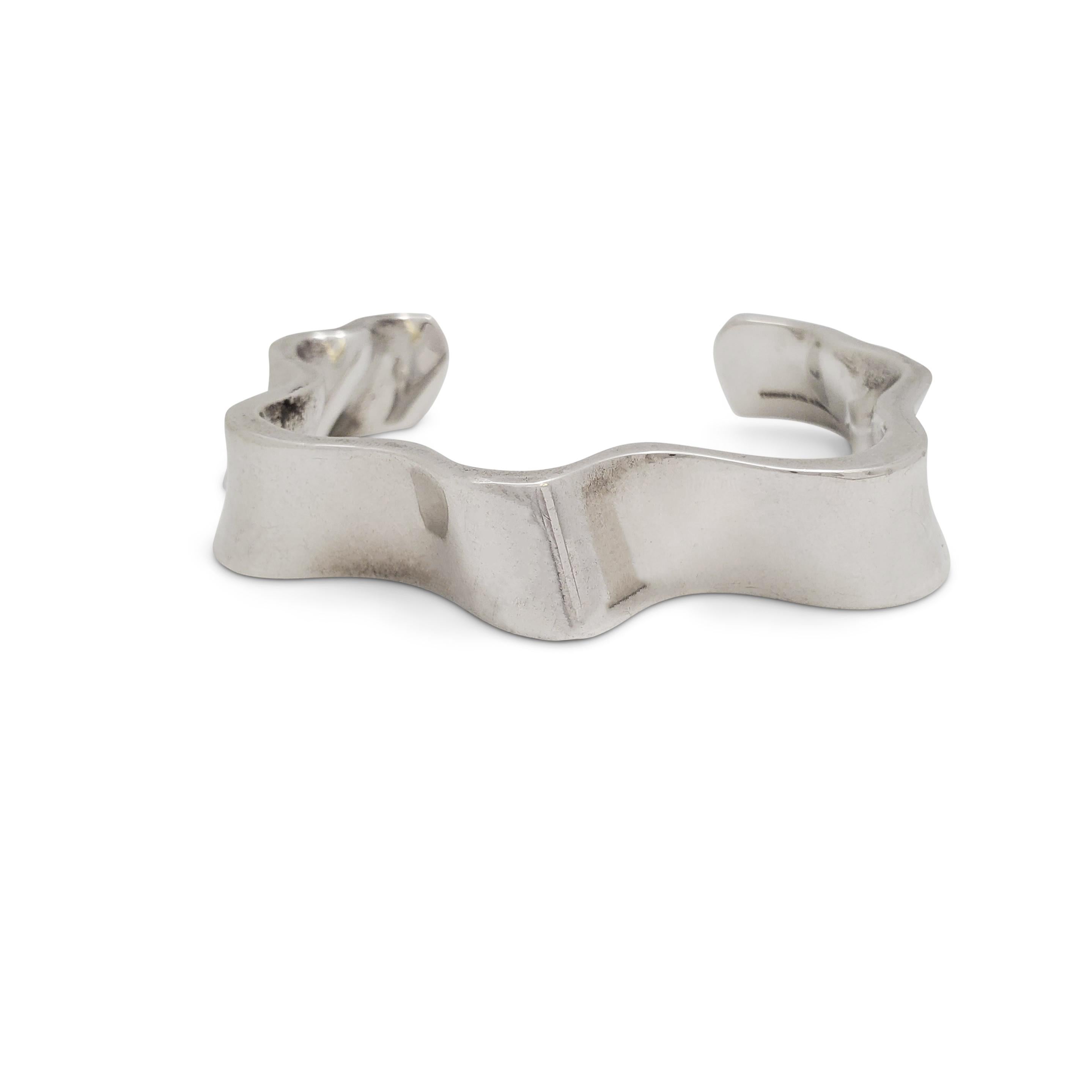 Authentic Tiffany & Co. 'Equus' cuff designed by Frank Gehry and crafted in sterling silver.  The sculptural waves wrap around the wrist in an open cuff design with an internal circumference of  5.5 inches and an opening of 1.5 inches.  The bracelet