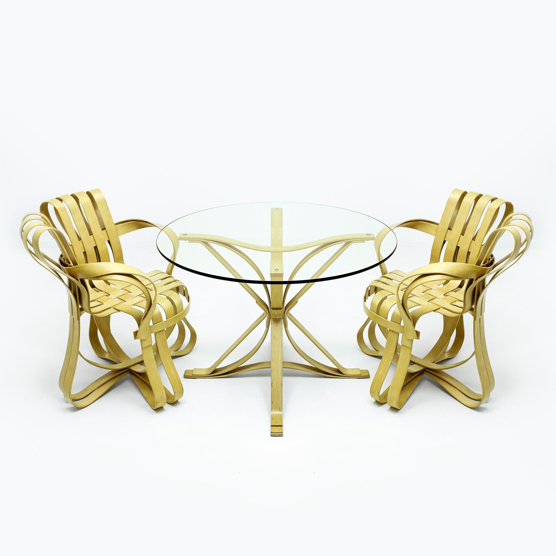 A Frank Gehry compact dining set featuring 2 bentwood maple ply Cross Check chairs matched to a maple and glass Face Off dining table manufactured by Knoll International.

Originally designed in the late 80’s Gehry’s Cross Check chairs and Face