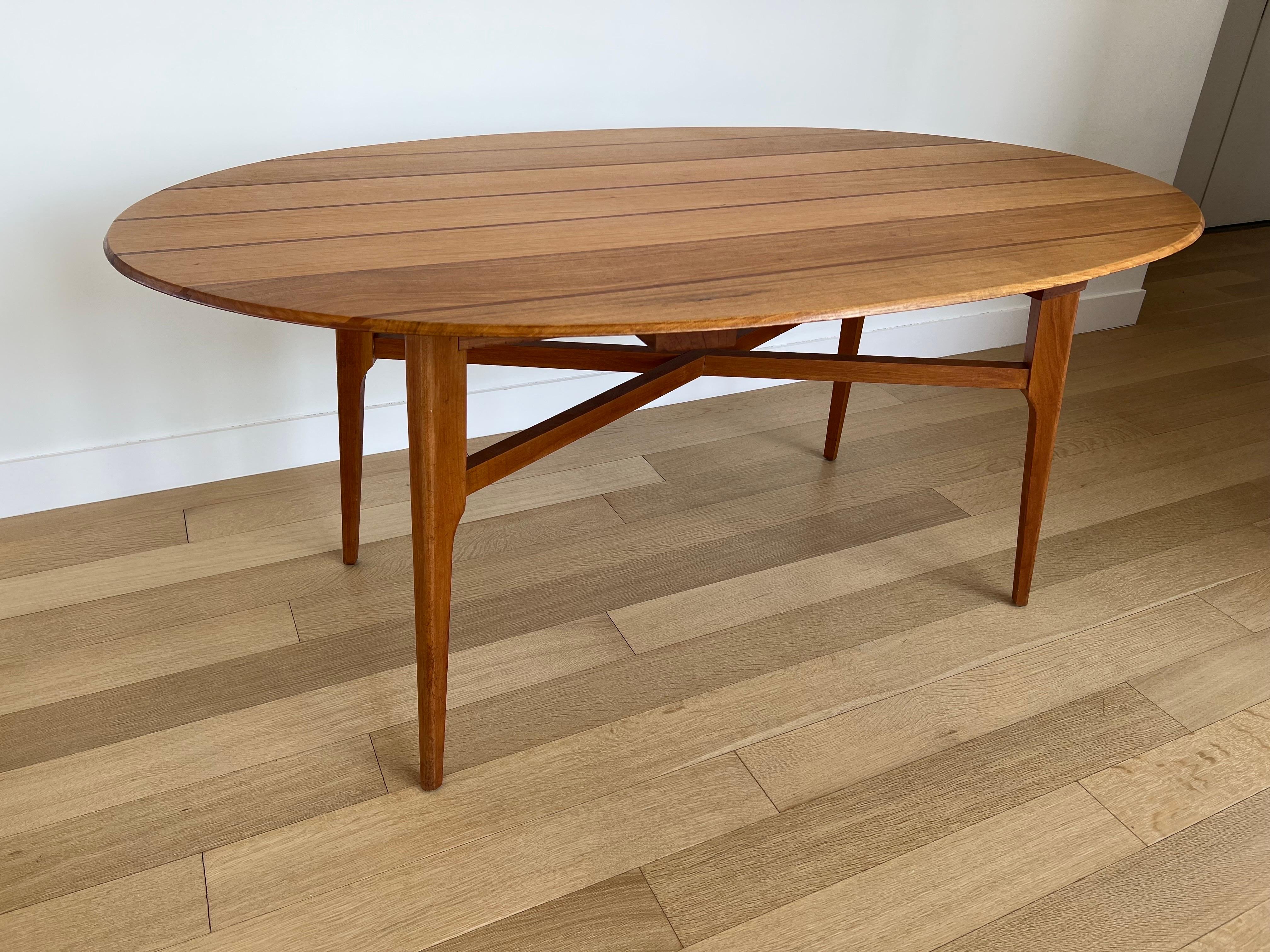 Une table de salle à manger elliptique intéressante et unique de Frank Guille. Plateau de forme ovale avec incrustation de teck et de bois et bord biseauté. 
