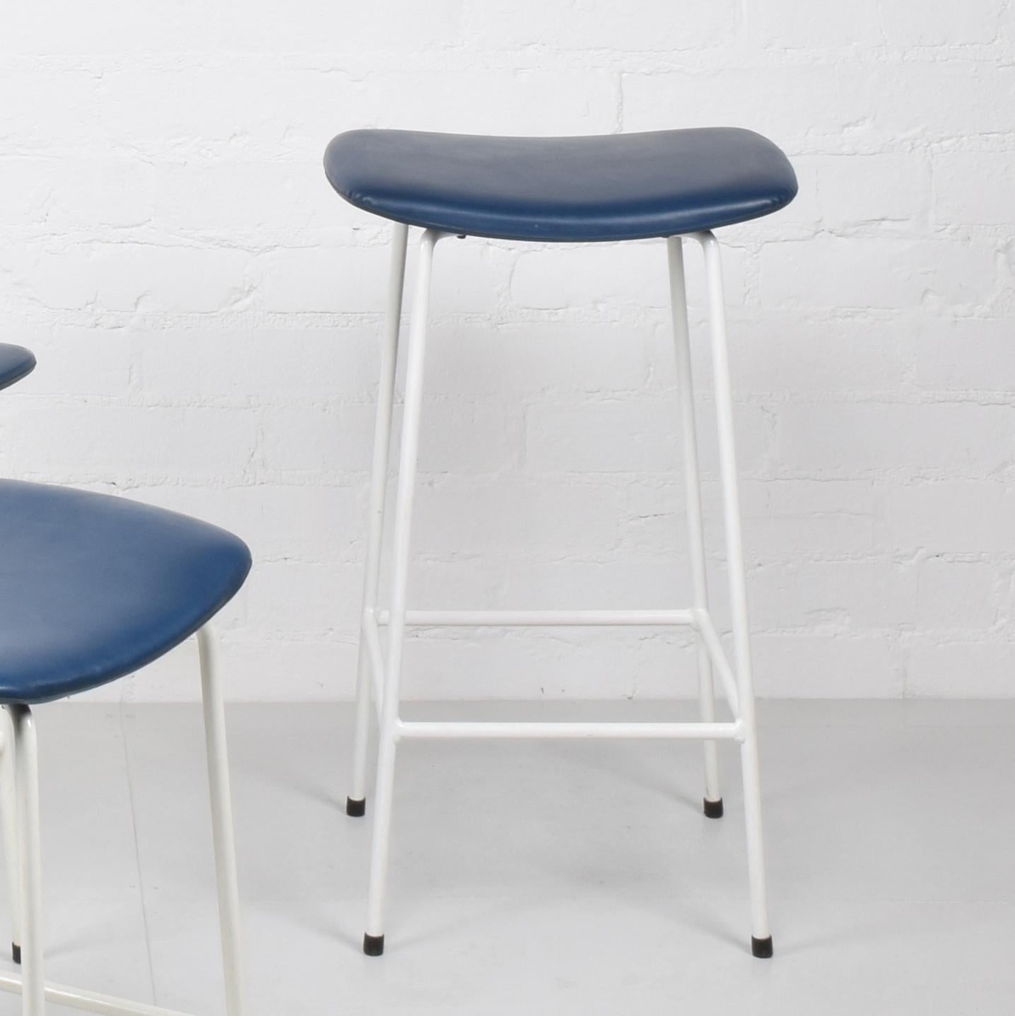 Frank Guille for Kandya
‘Program’ stool, 1958
(High version: 61 cm seat height)

White powder coated steel frame, vinyl upholstery on moulded plywood seat. Label to underside.

Good original condition.

Dimensions approx.: length 38.5 cm, width 29.5